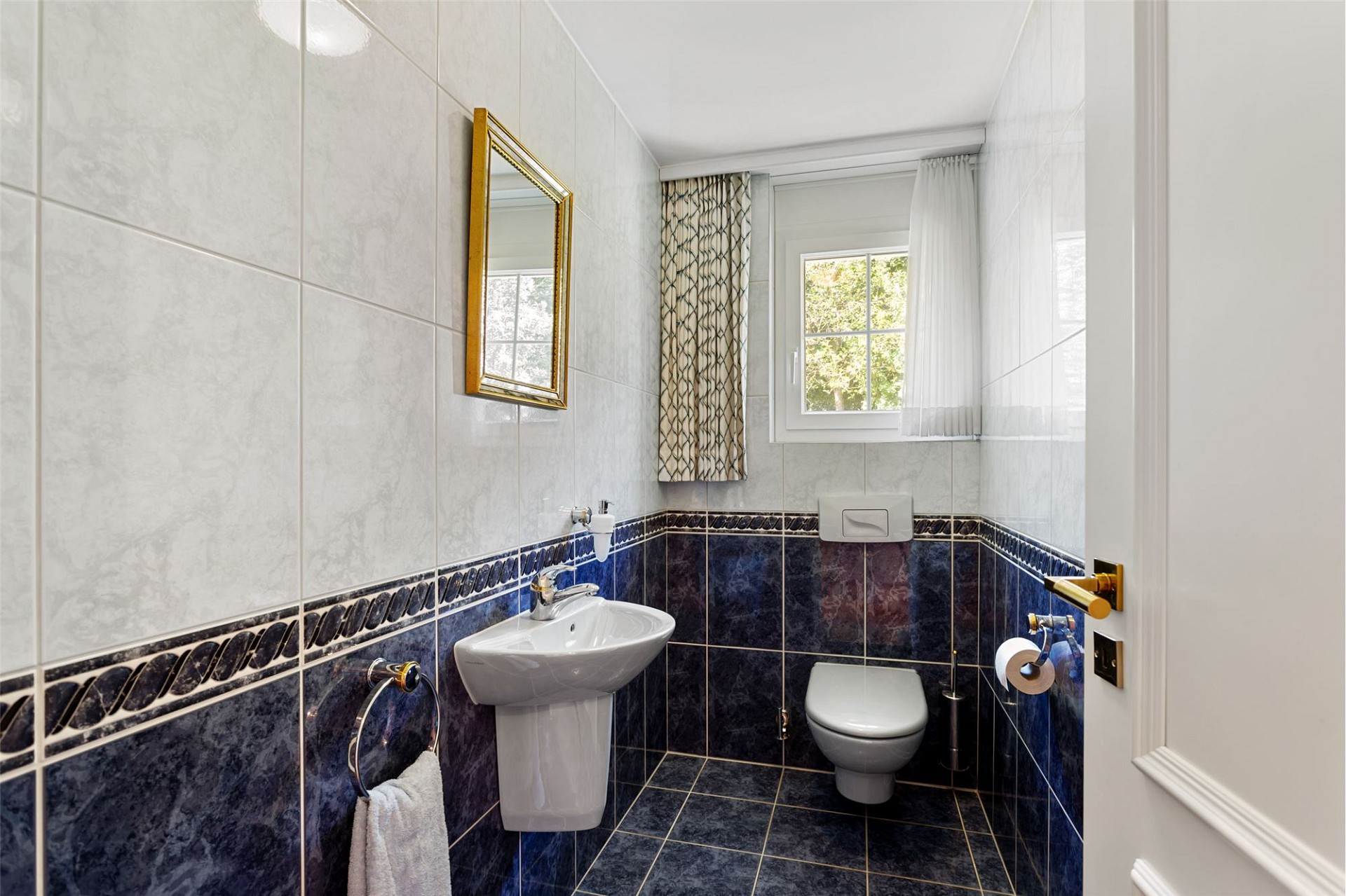 Gäste-WC mit dunkelblauen Fliesen