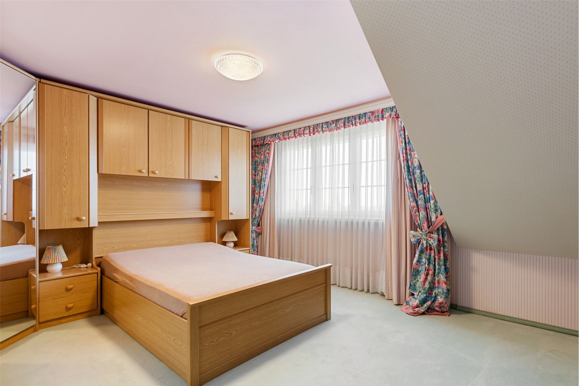 Schlafzimmer mit Dachschräge und Holzschrankwand