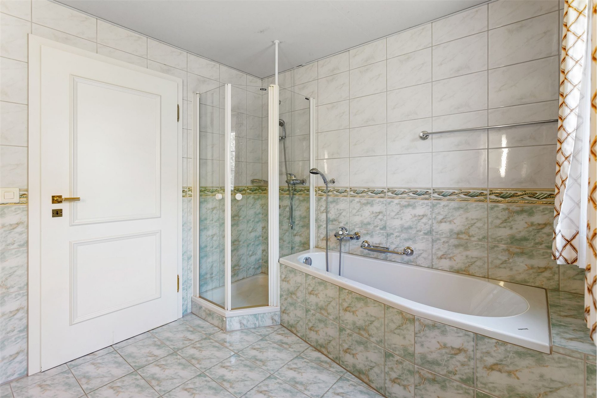Helles Badezimmer mit Badewanne und Duschkabine