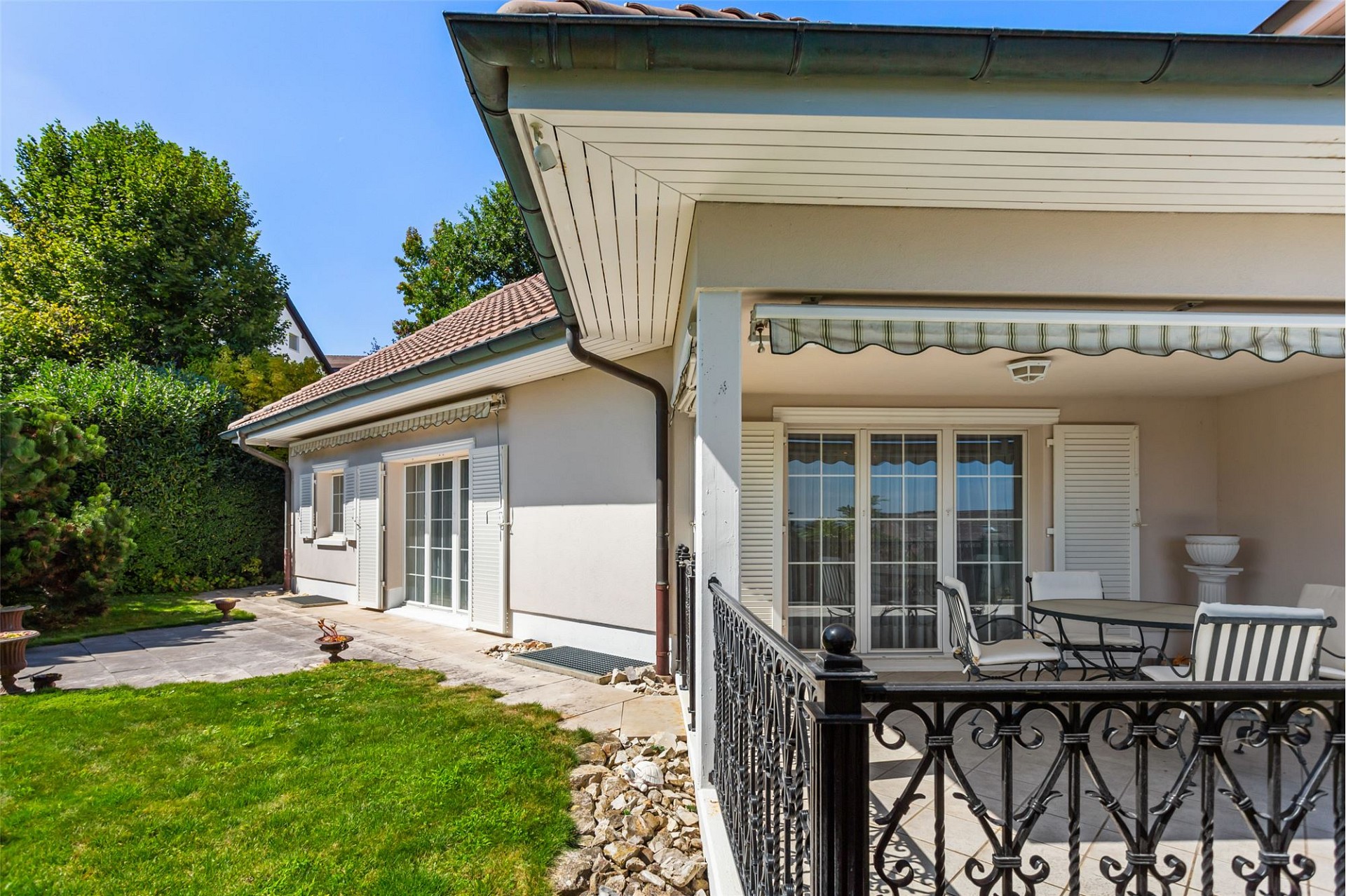 Helle Terrasse und Gartenansicht eines Wohnhauses