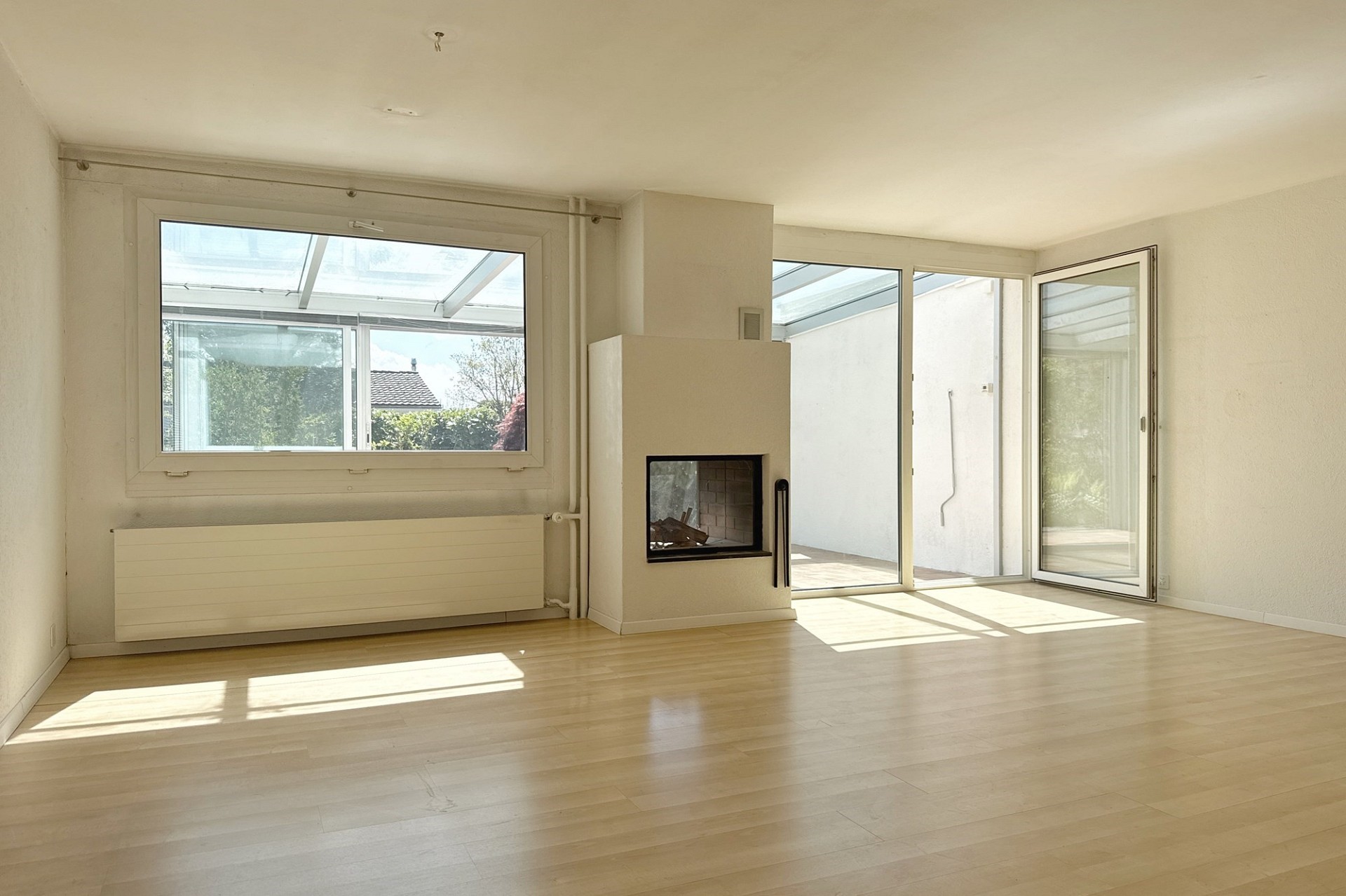 Heller Wohnraum mit Kamin und großer Fensterfront