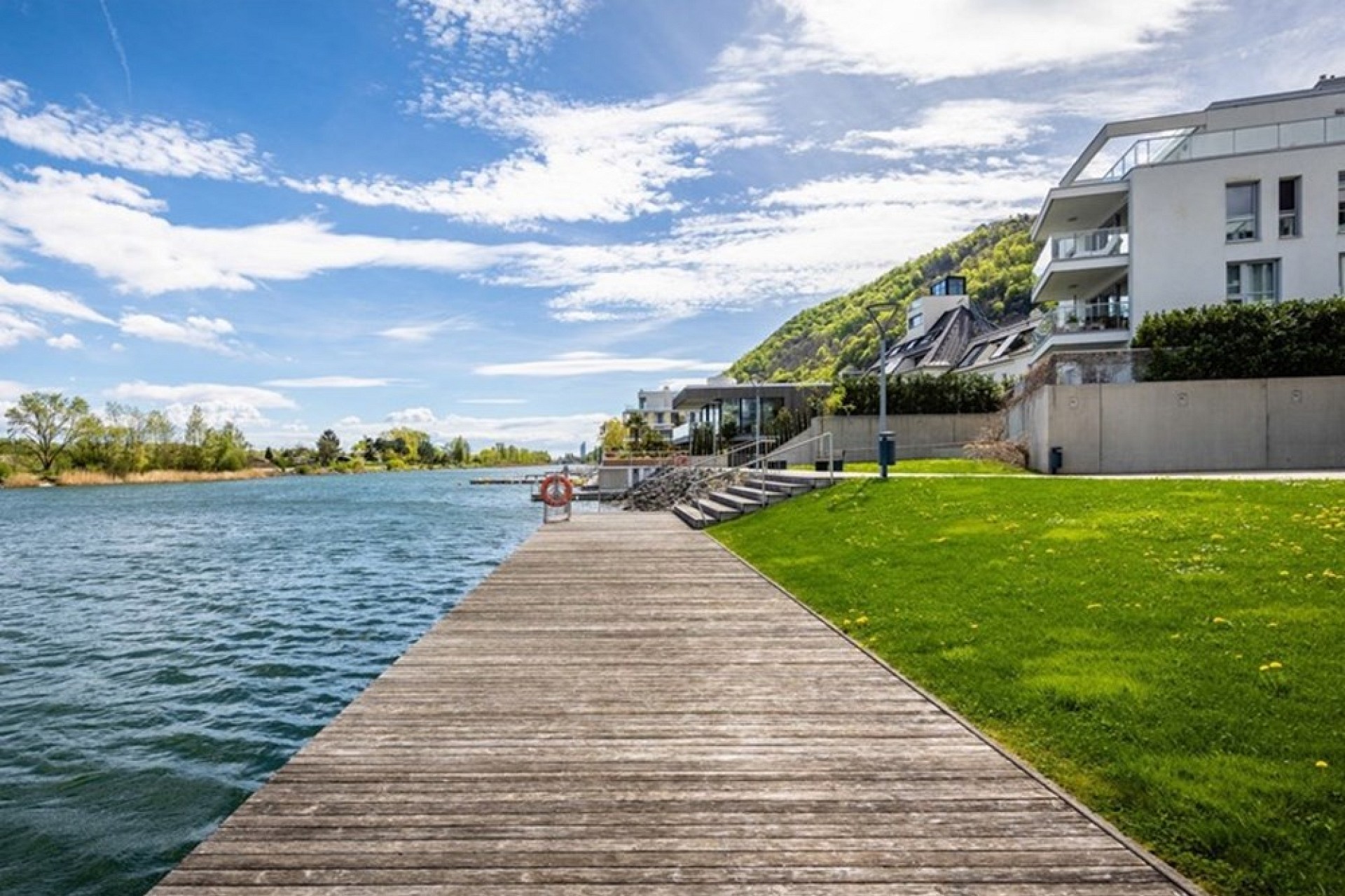 Uferpromenade am Wasser mit moderner Wohnbebauung