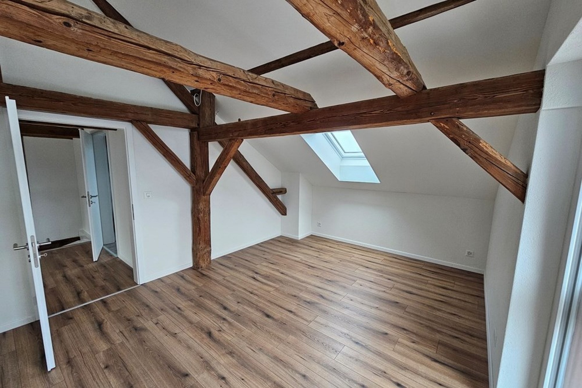 Ausgebauter Dachraum mit sichtbaren Holzbalken