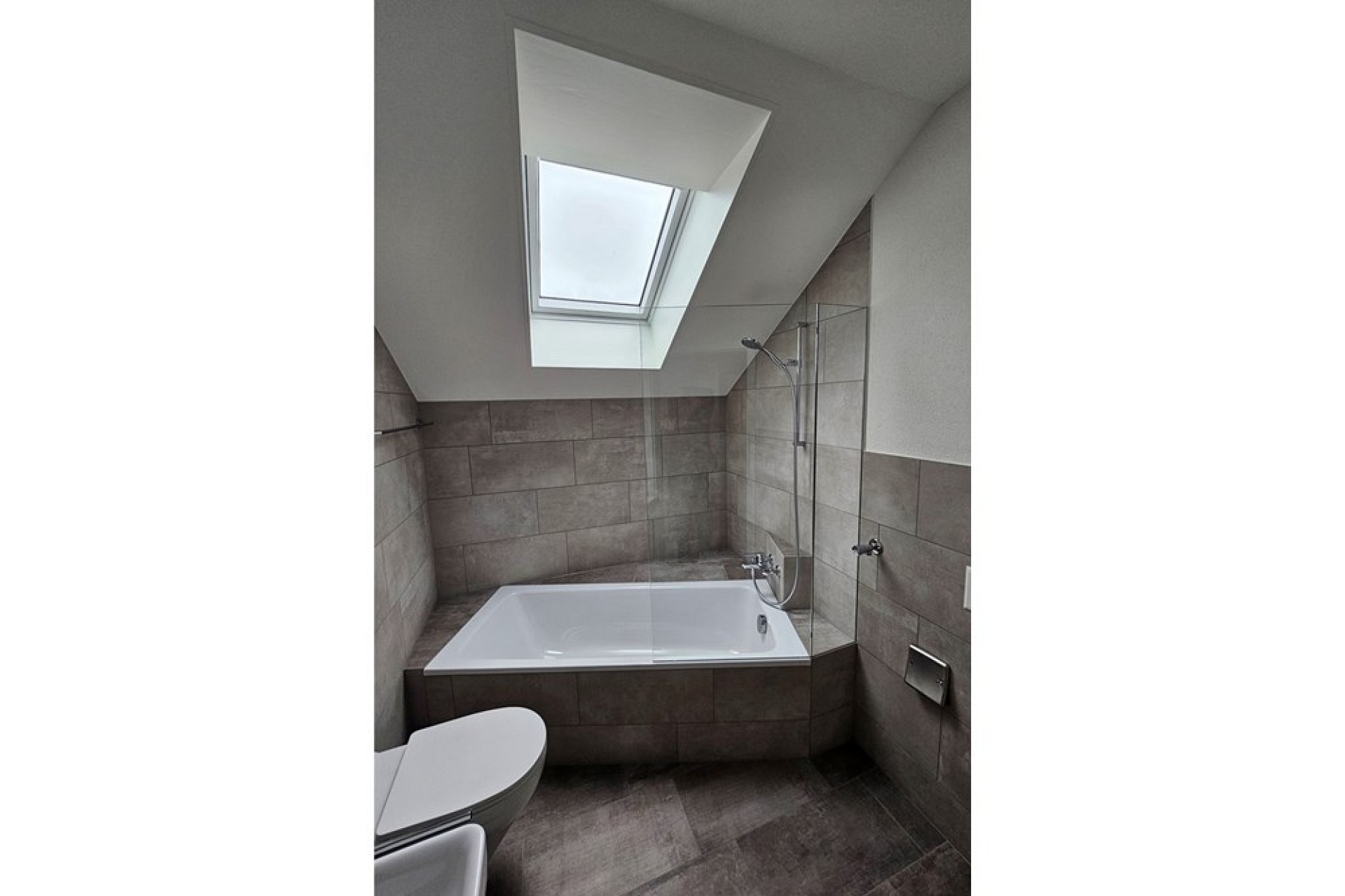 Modernes Bad mit Dachfenster und Badewanne