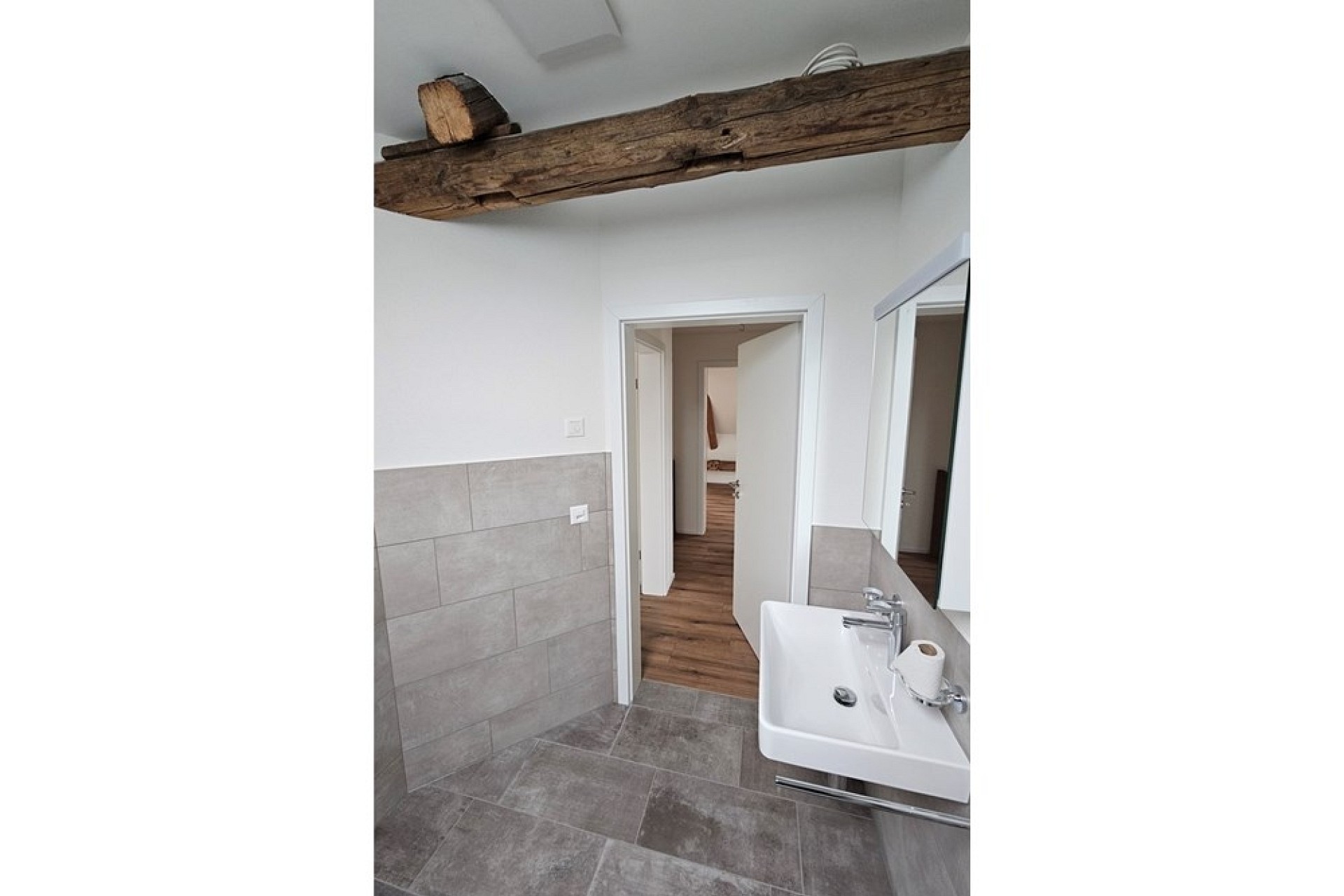 Modernes Badezimmer mit sichtbarem Holzbalken