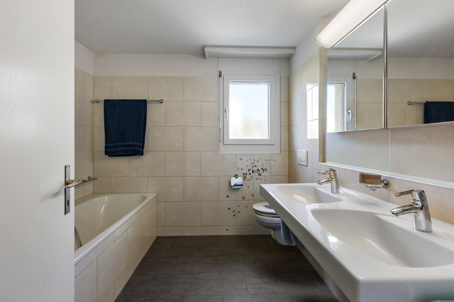 Helles Badezimmer mit Doppelwaschbecken und Wanne