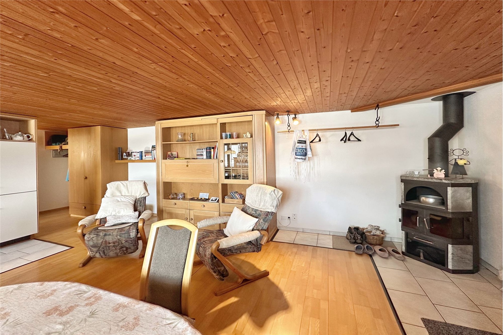 Gemütliches Wohnzimmer mit Holzdecke und Kaminofen