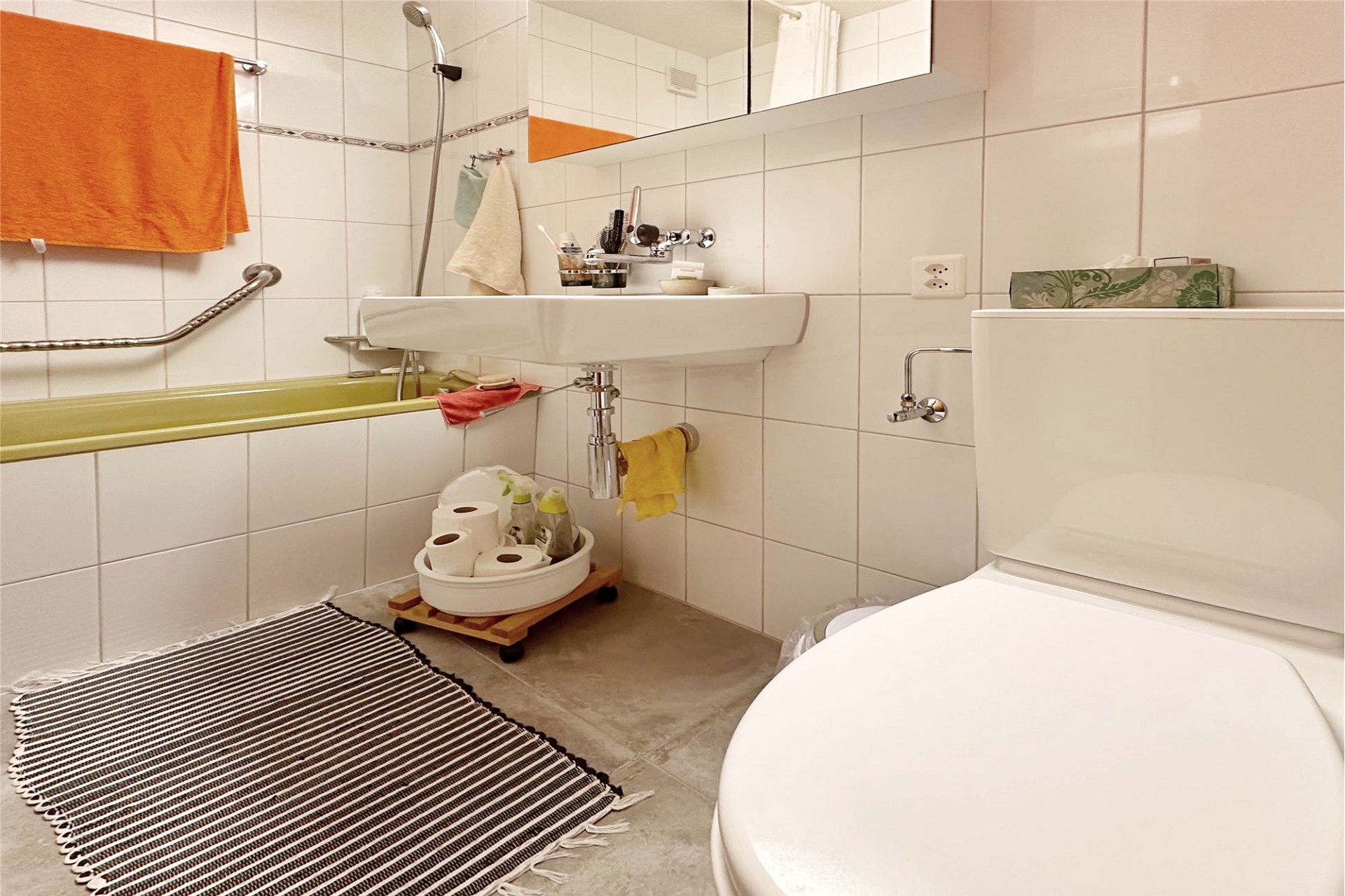 Kleines Badezimmer mit Badewanne und Waschbecken