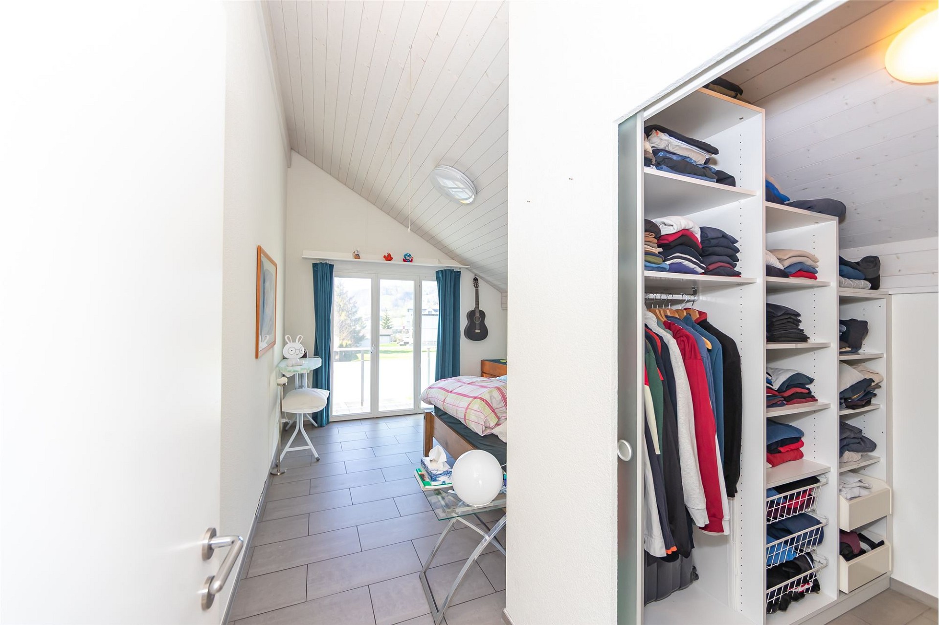 Dachzimmer mit offener Kleideraufbewahrung