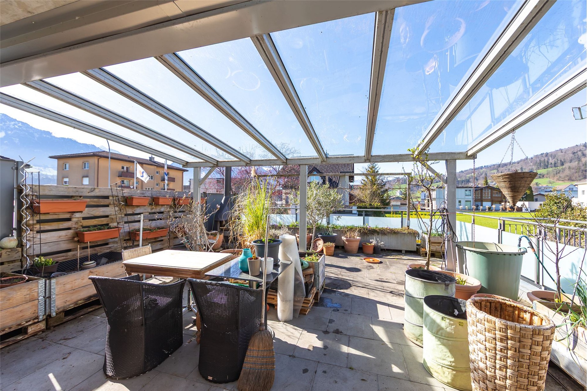 Überdachte Dachterrasse mit Pflanzen und Sitzbereich