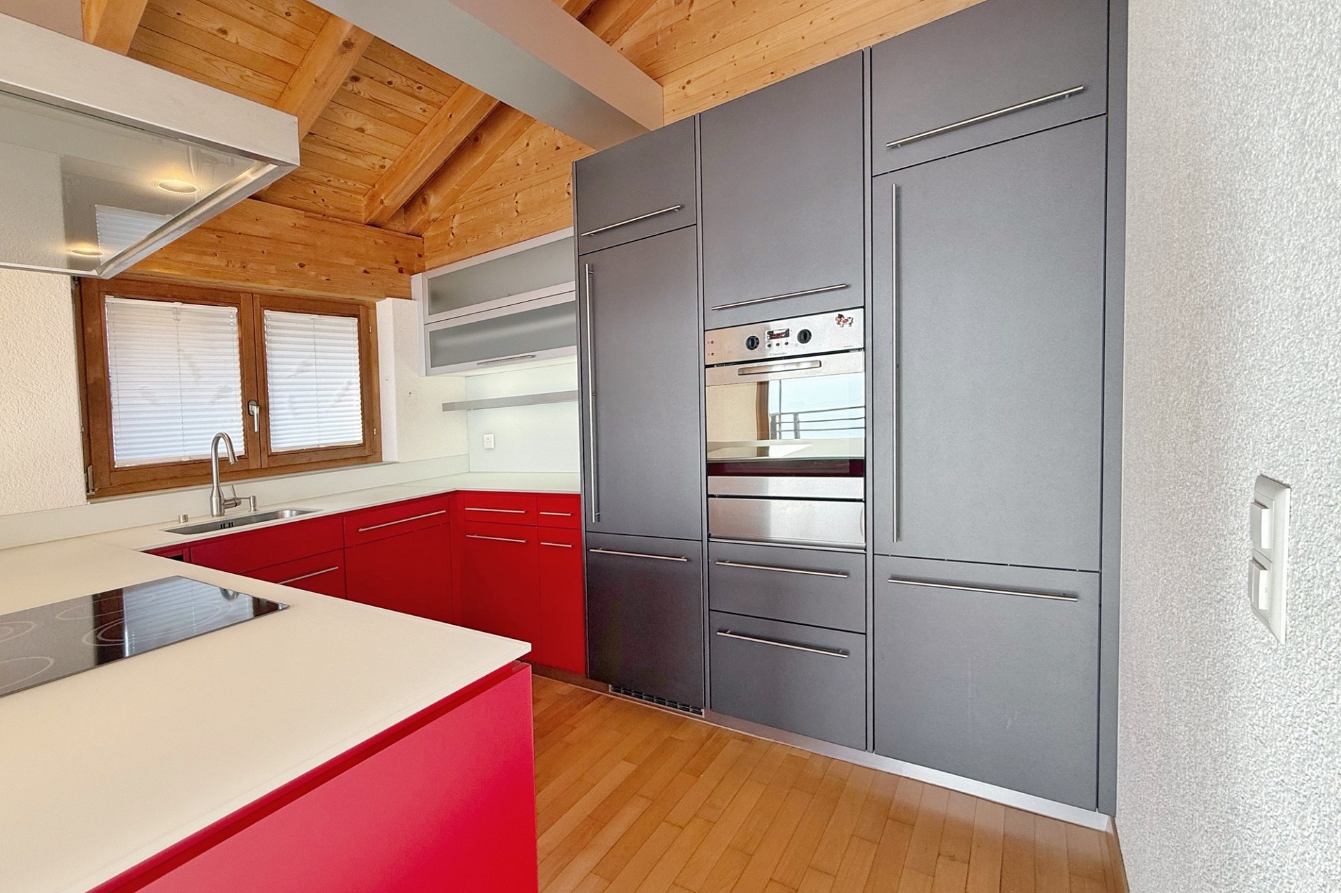 Moderne Küche mit Holzdecke und roten Fronten