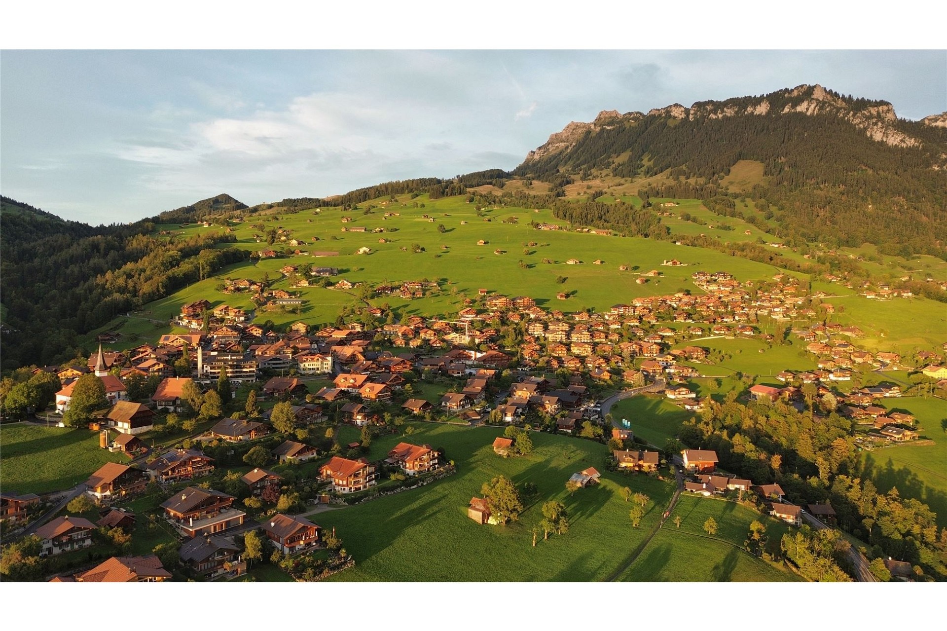 Luftaufnahme eines alpinen Dorfes im Abendlicht