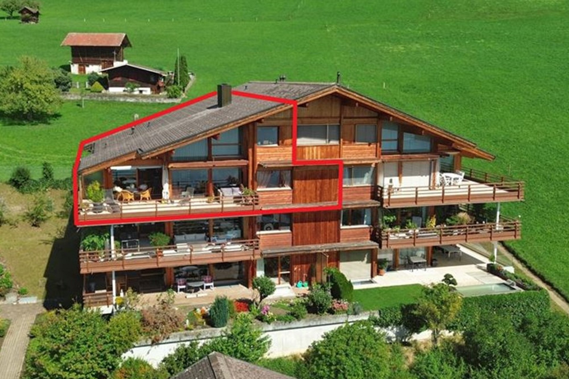 Alpenchalet mit Balkonen in grüner Umgebung