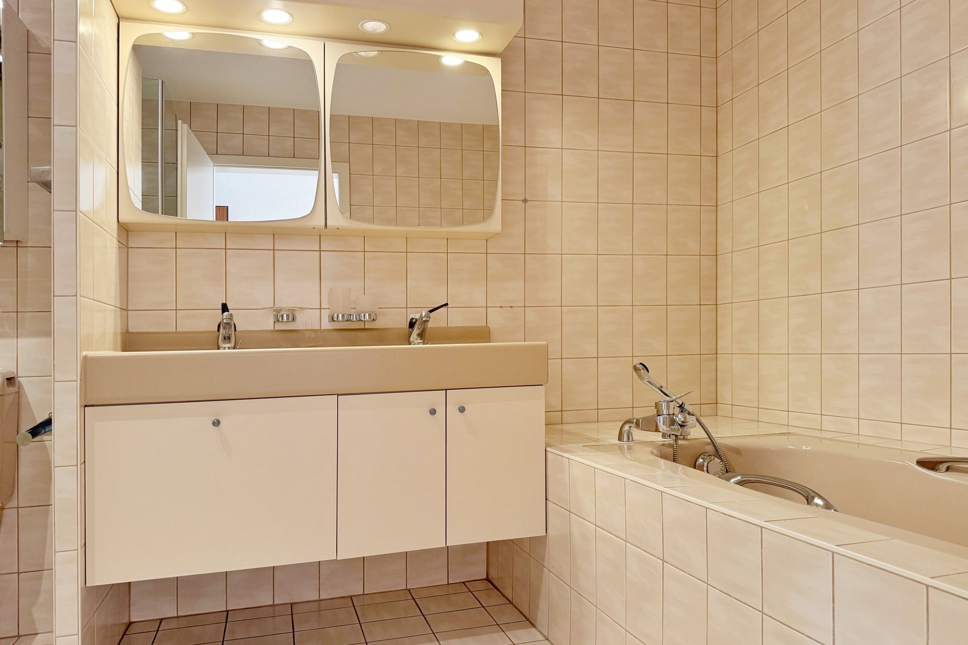 Badezimmer mit Badewanne und Spiegelschrank