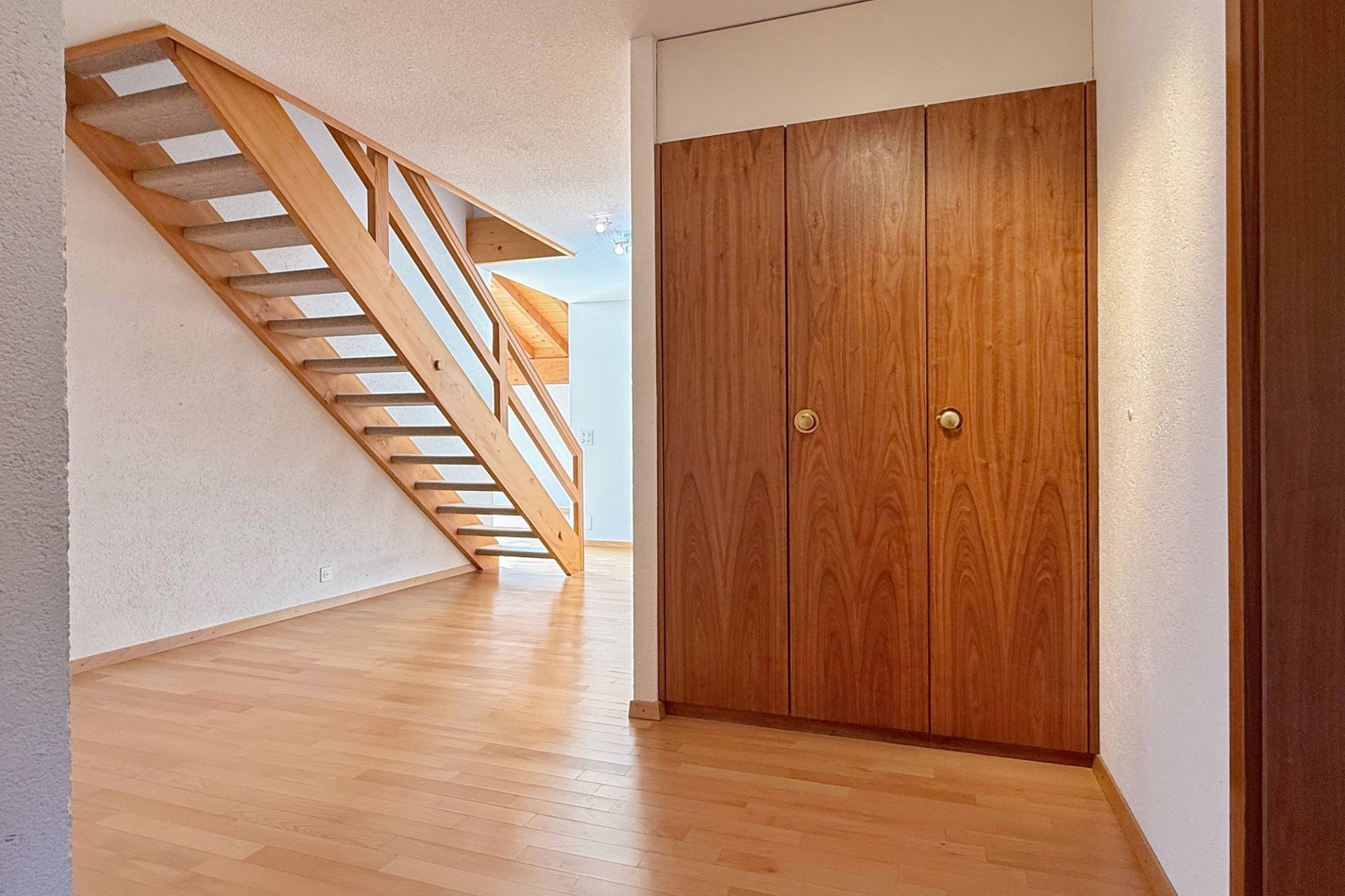 Flur mit Holztreppe und Einbauschrank