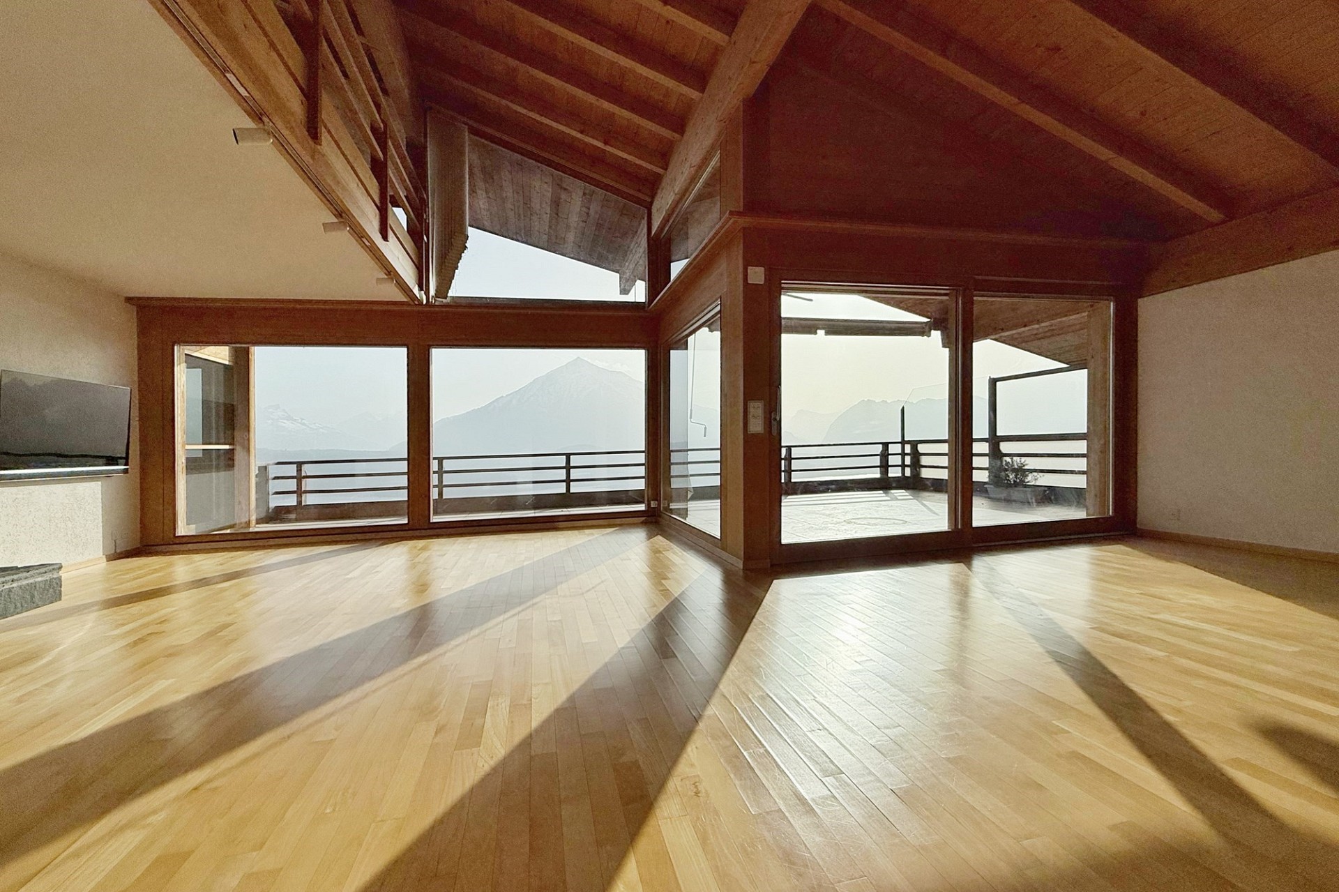 Großer Wohnraum mit Holzdecke und Bergblick