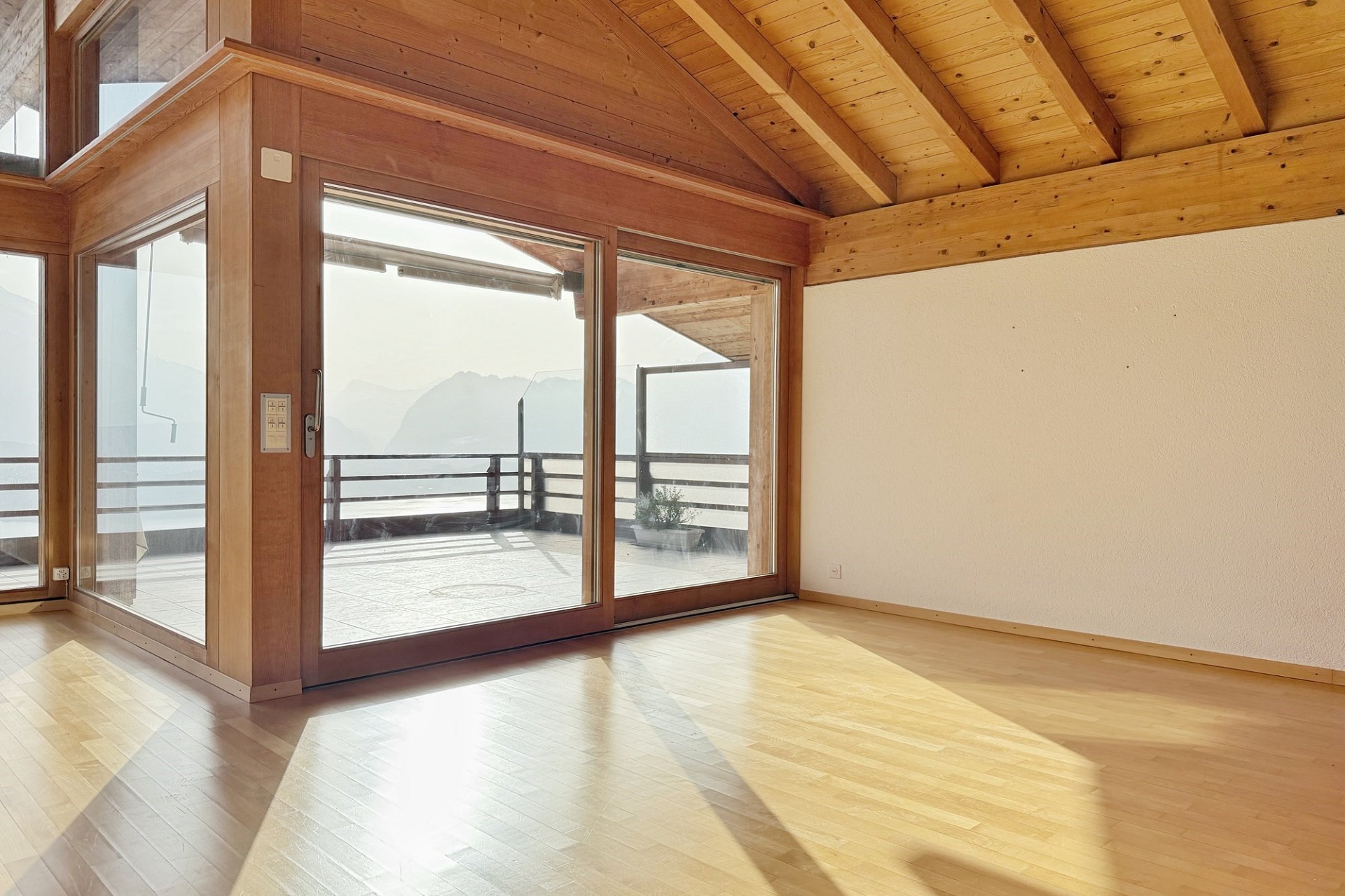 Heller Raum mit Holzdecke und großer Glasfront