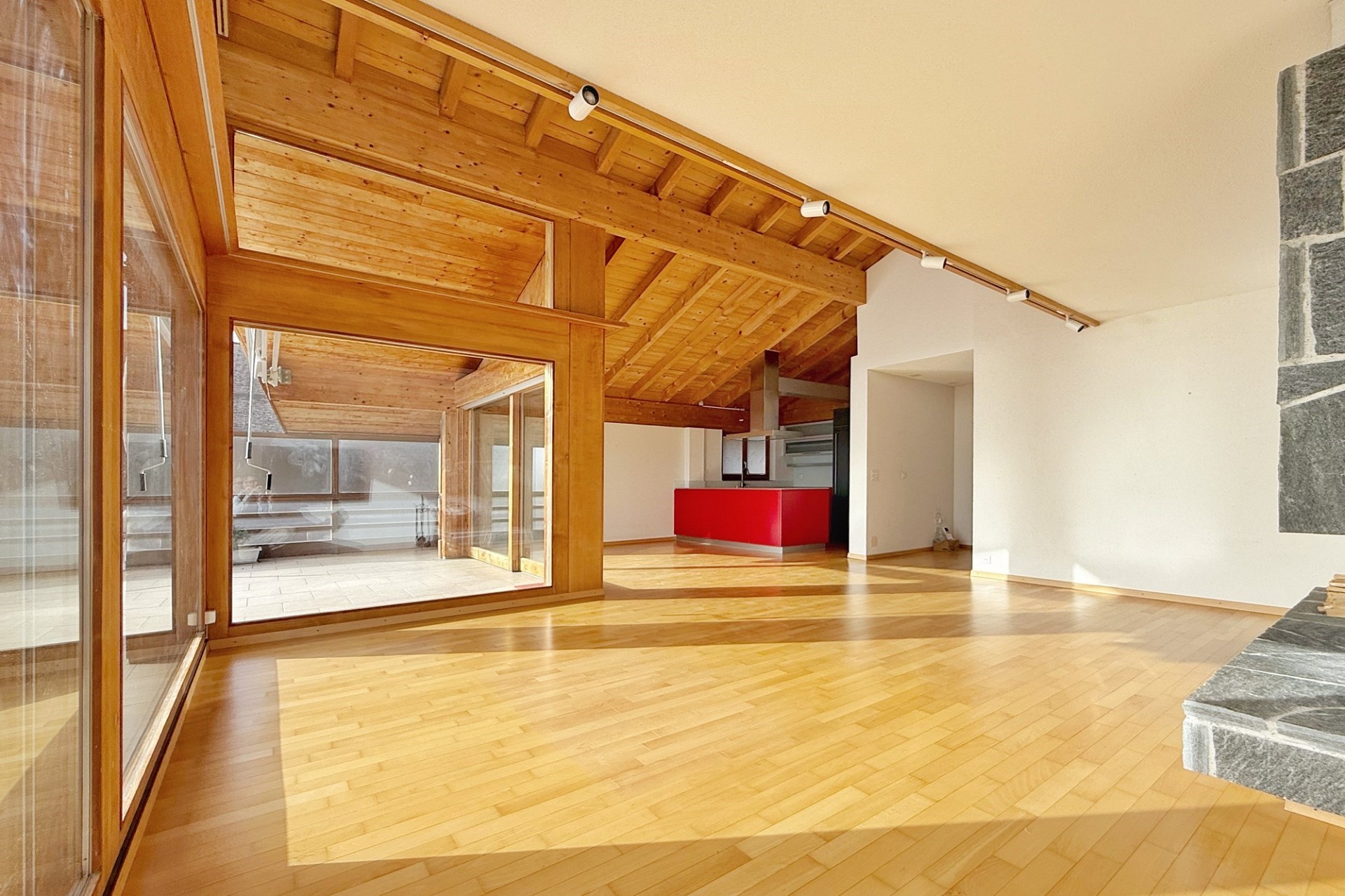 Heller Wohnraum mit Holzdecke und offener Raumstruktur