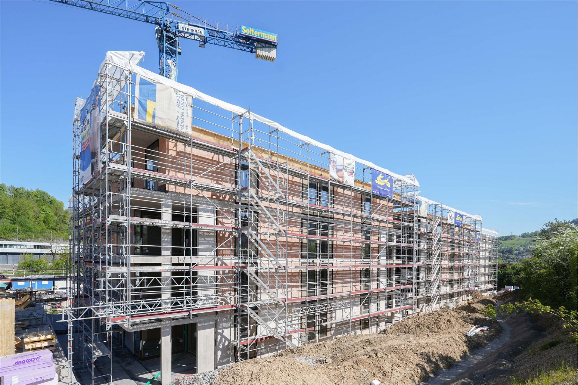 Wohngebäude im Bau mit Gerüst und Kran