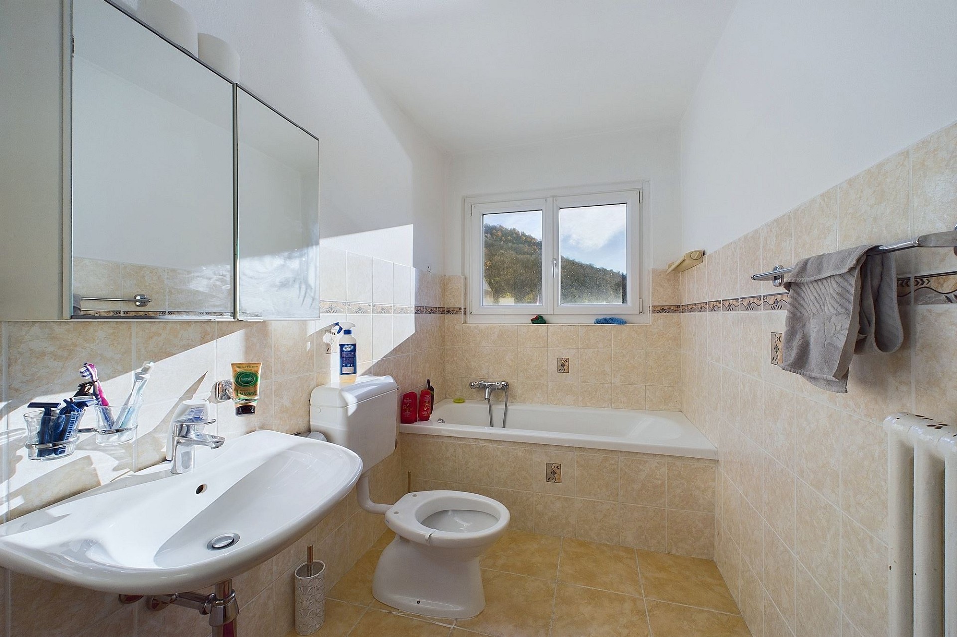 Helles Badezimmer mit Badewanne, Waschbecken und WC