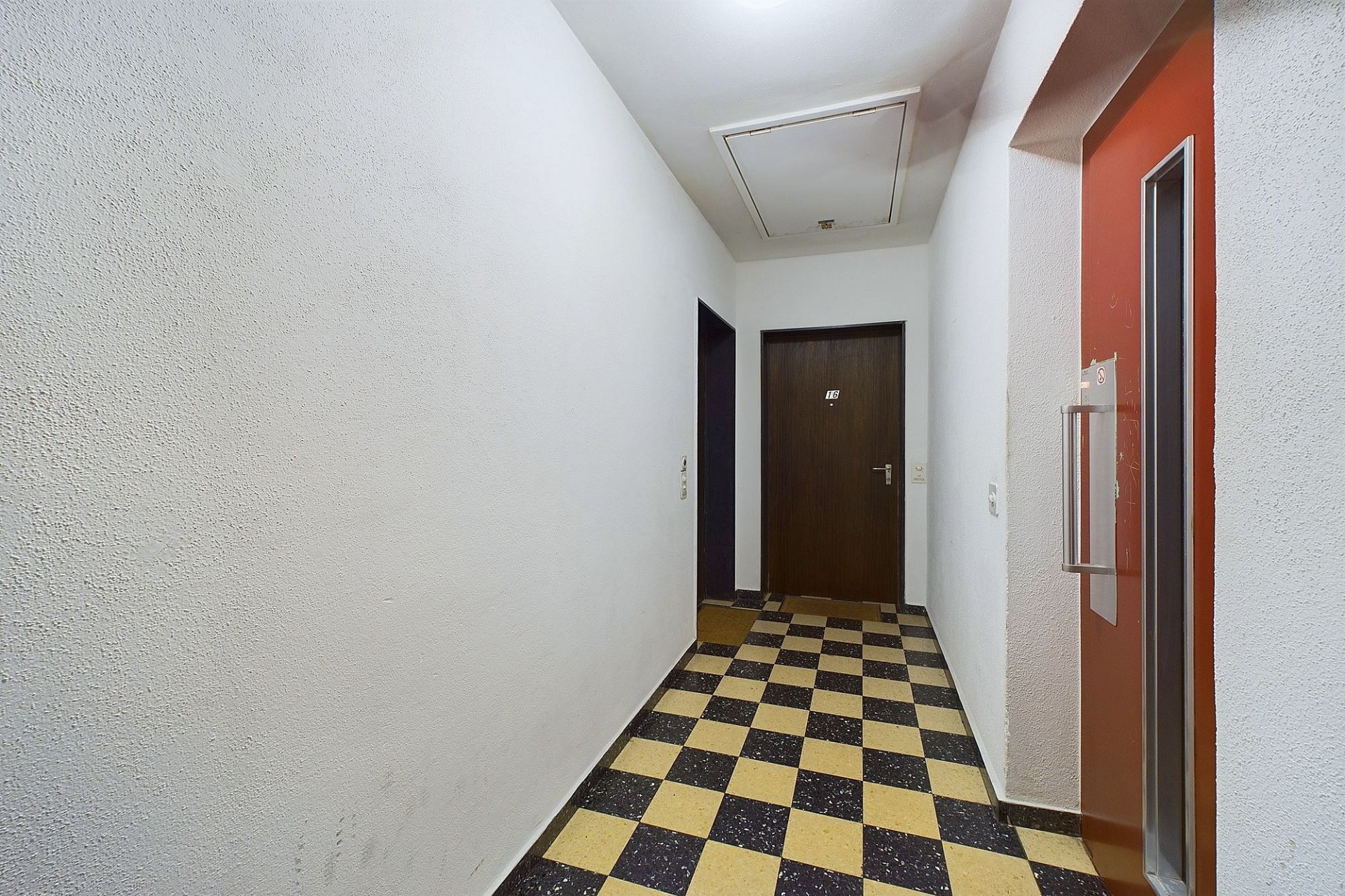 Hausflur mit Kachelboden und Wohnungstür