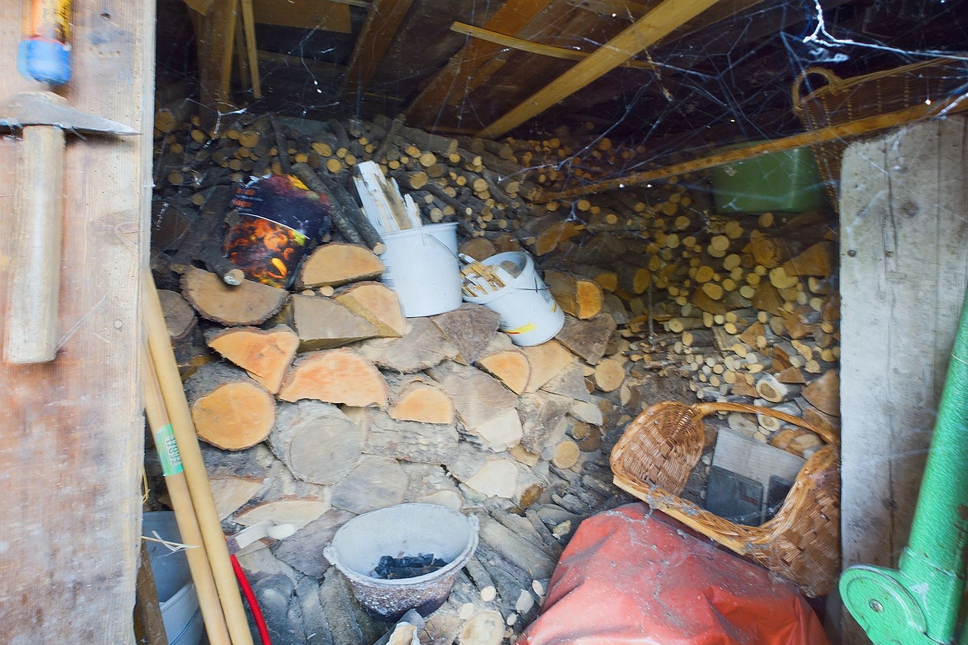 Holzlagerraum mit Brennholz und Werkzeugen