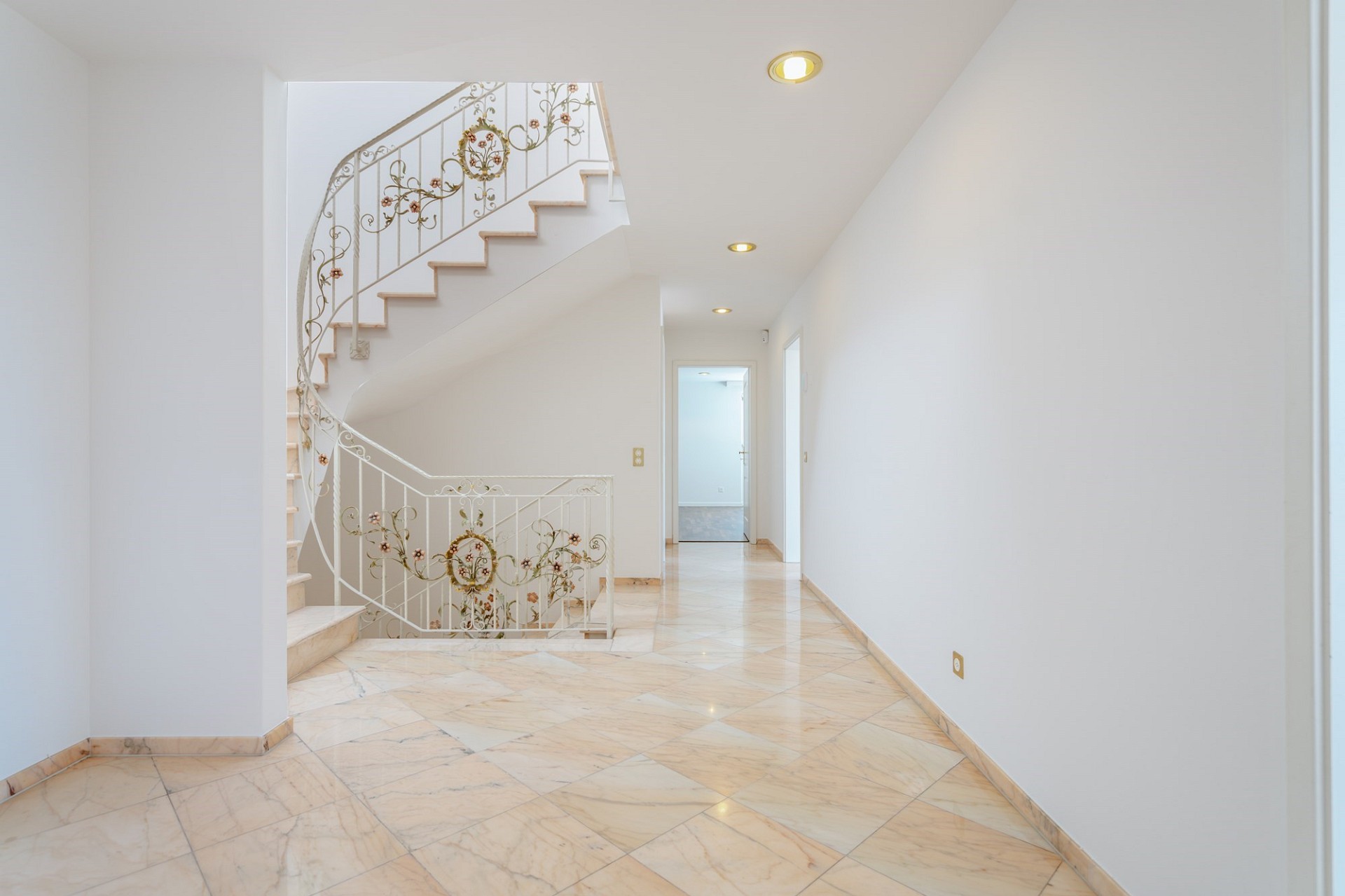 Heller Flur mit geschwungener Treppe