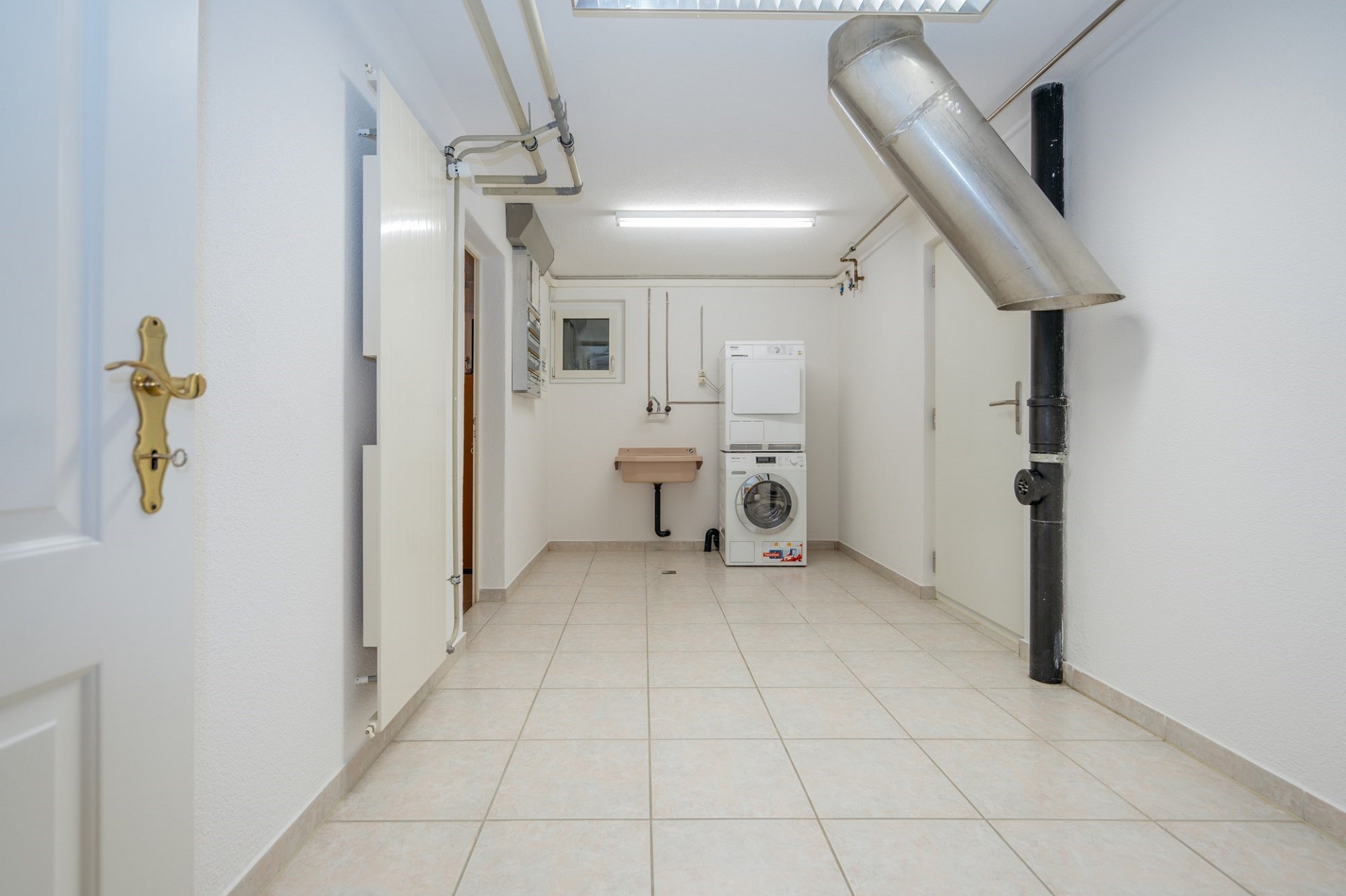 Hauswirtschaftsraum mit Waschmaschine und Technikinstallation