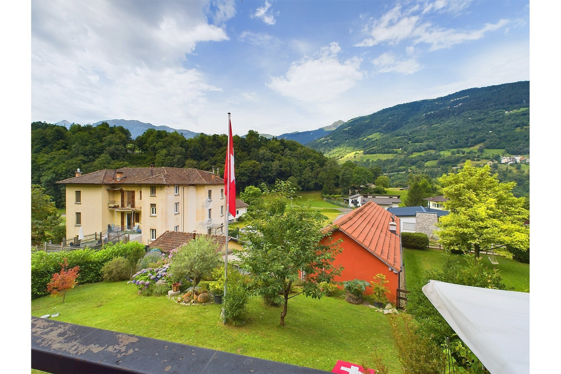 Blick auf ein Haus mit Garten und Berglandschaft