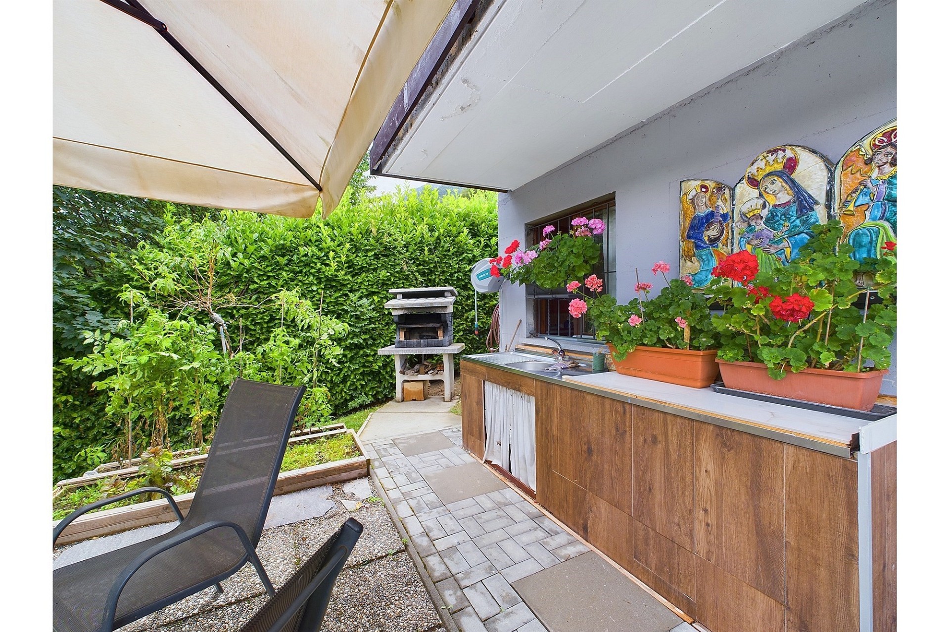 Überdachte Gartenterrasse mit Outdoor-Küche