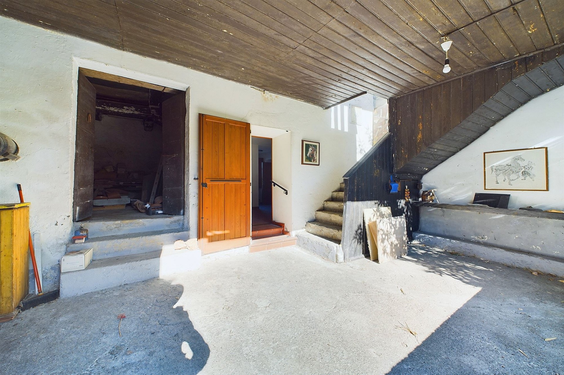 Rustikaler Innenraum mit Treppe und kleiner Holzöffnung