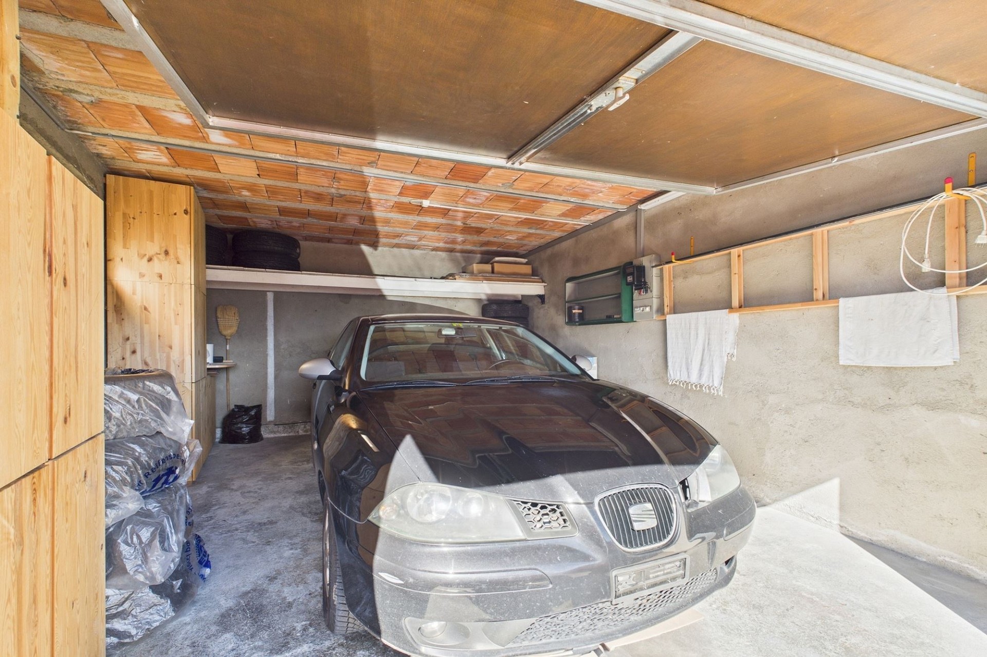 Garage mit geparktem Auto und Lagerbereich