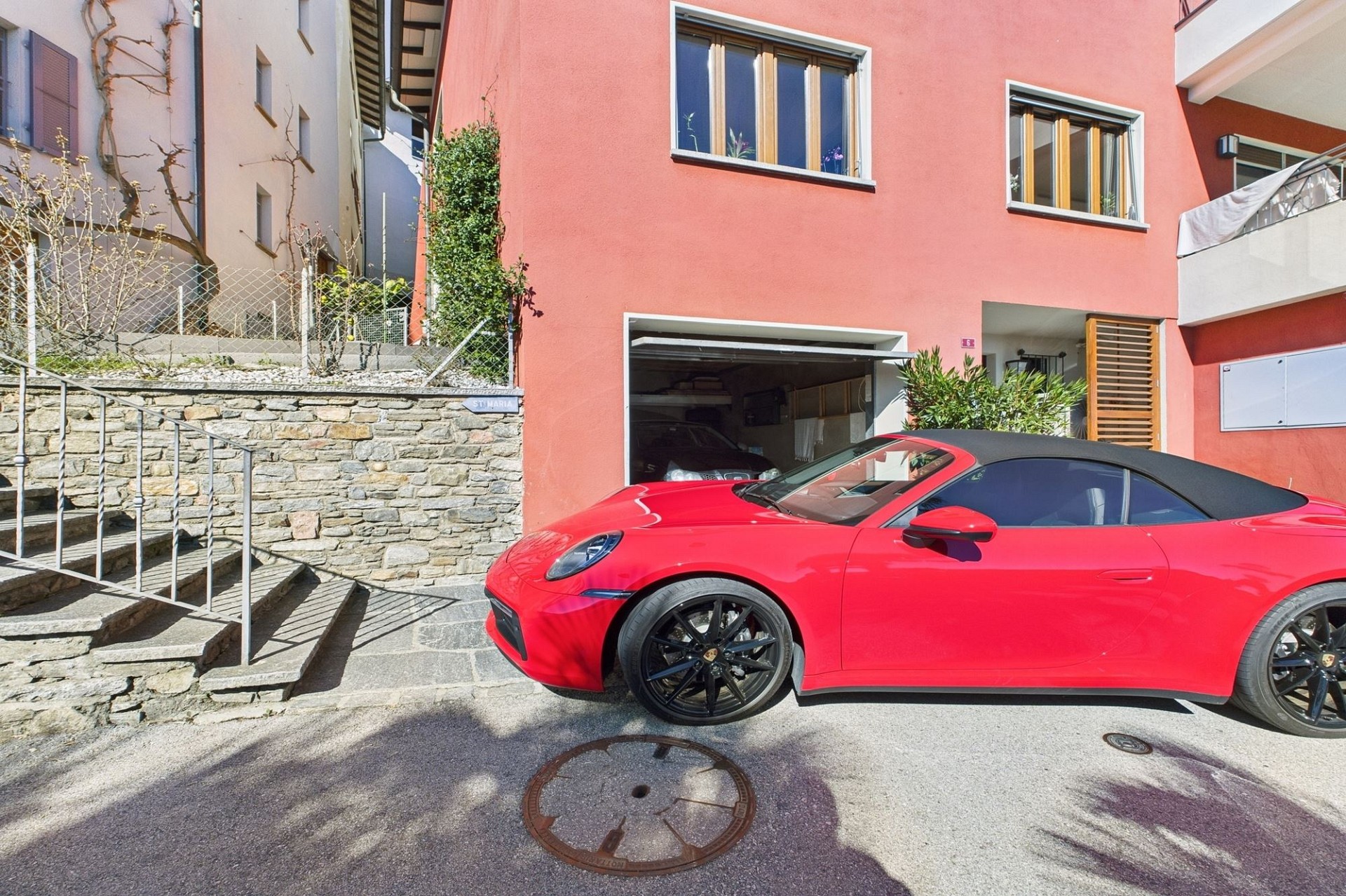 Außenansicht eines Wohnhauses mit Garage und Sportwagen