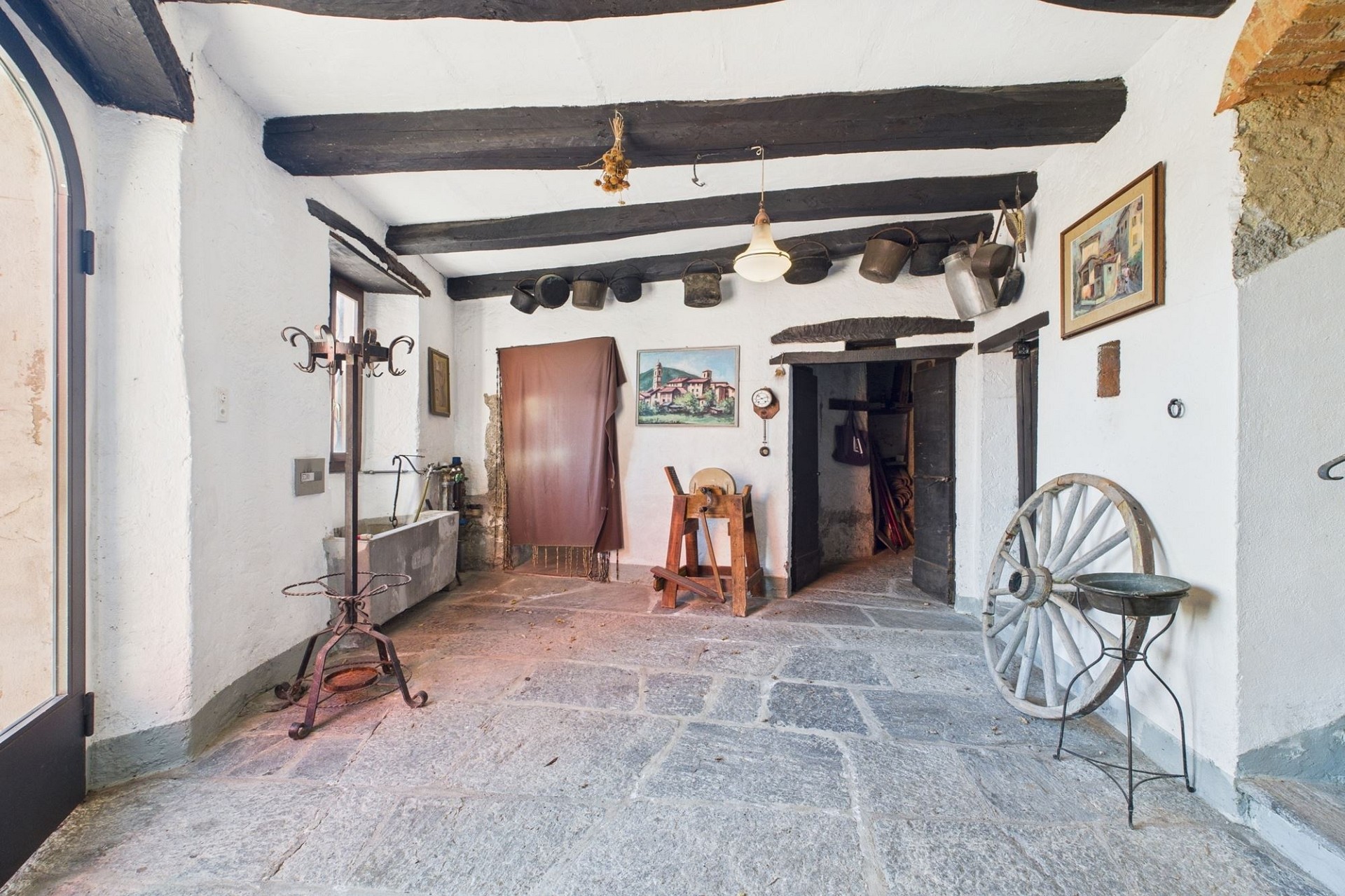 Rustikaler Innenraum mit Steinboden und Holzbalken