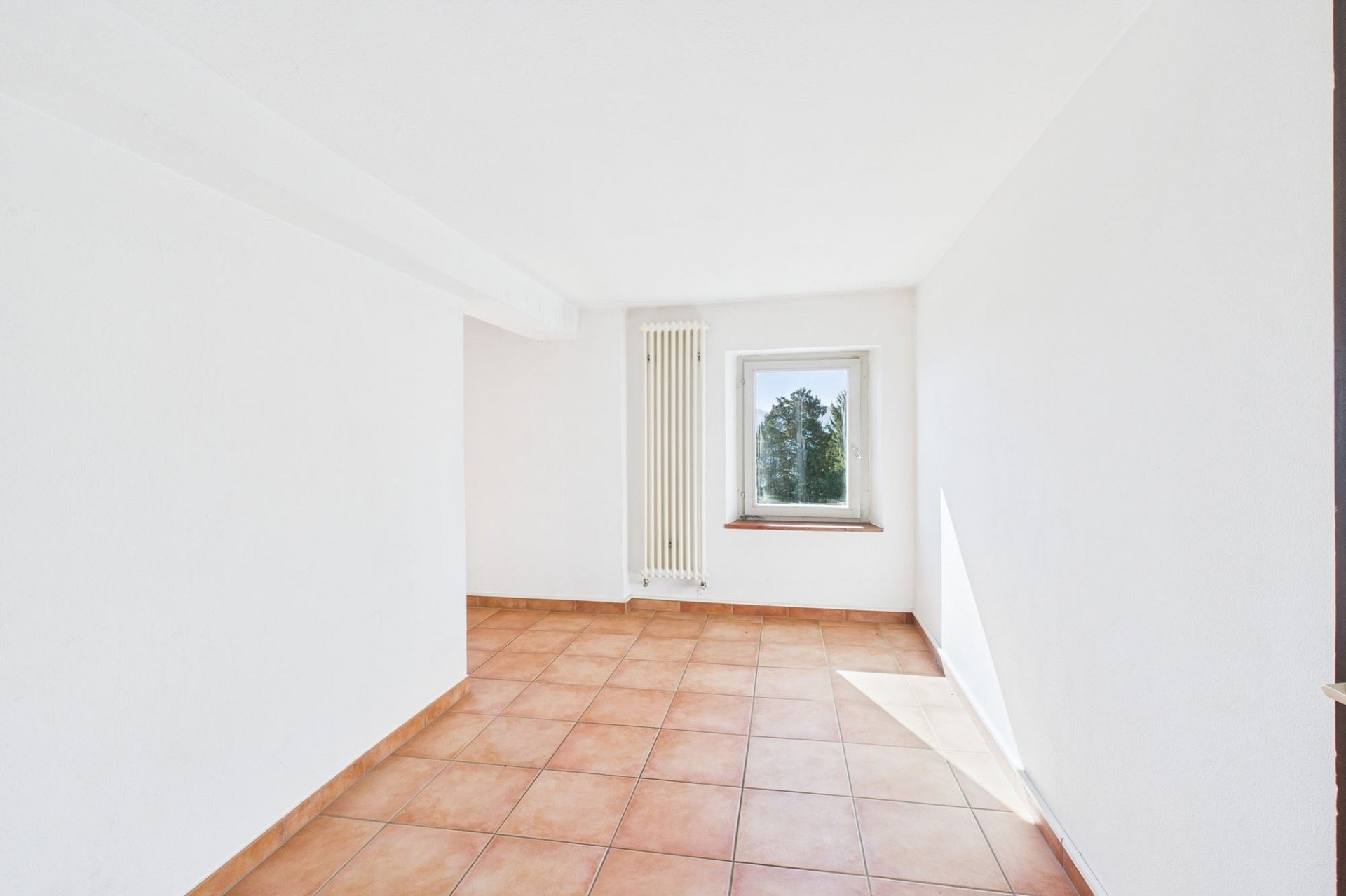 Heller leerer Raum mit Fliesenboden und Fenster