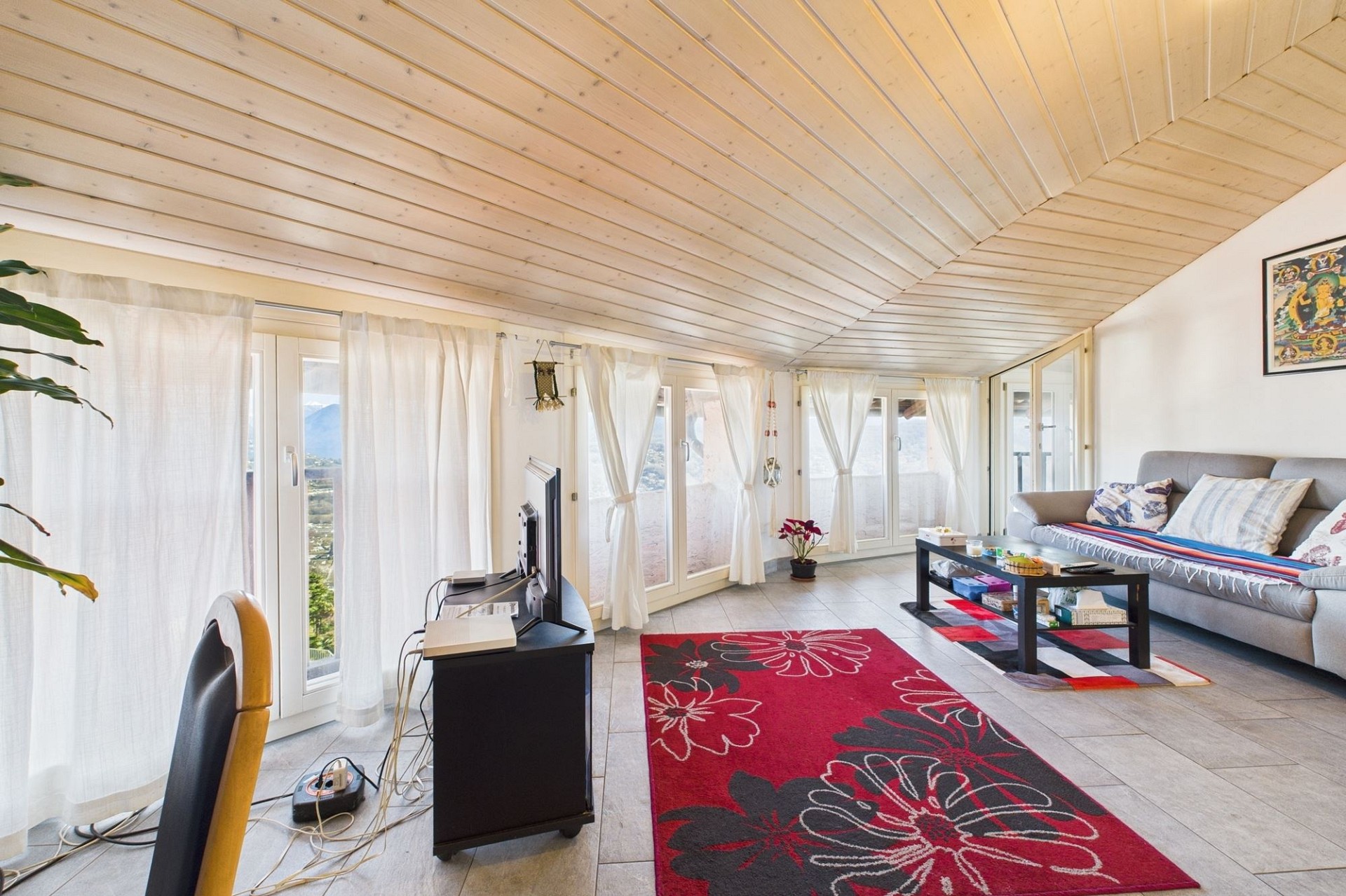 Helles Wohnzimmer mit Dachschräge und Panoramafenstern