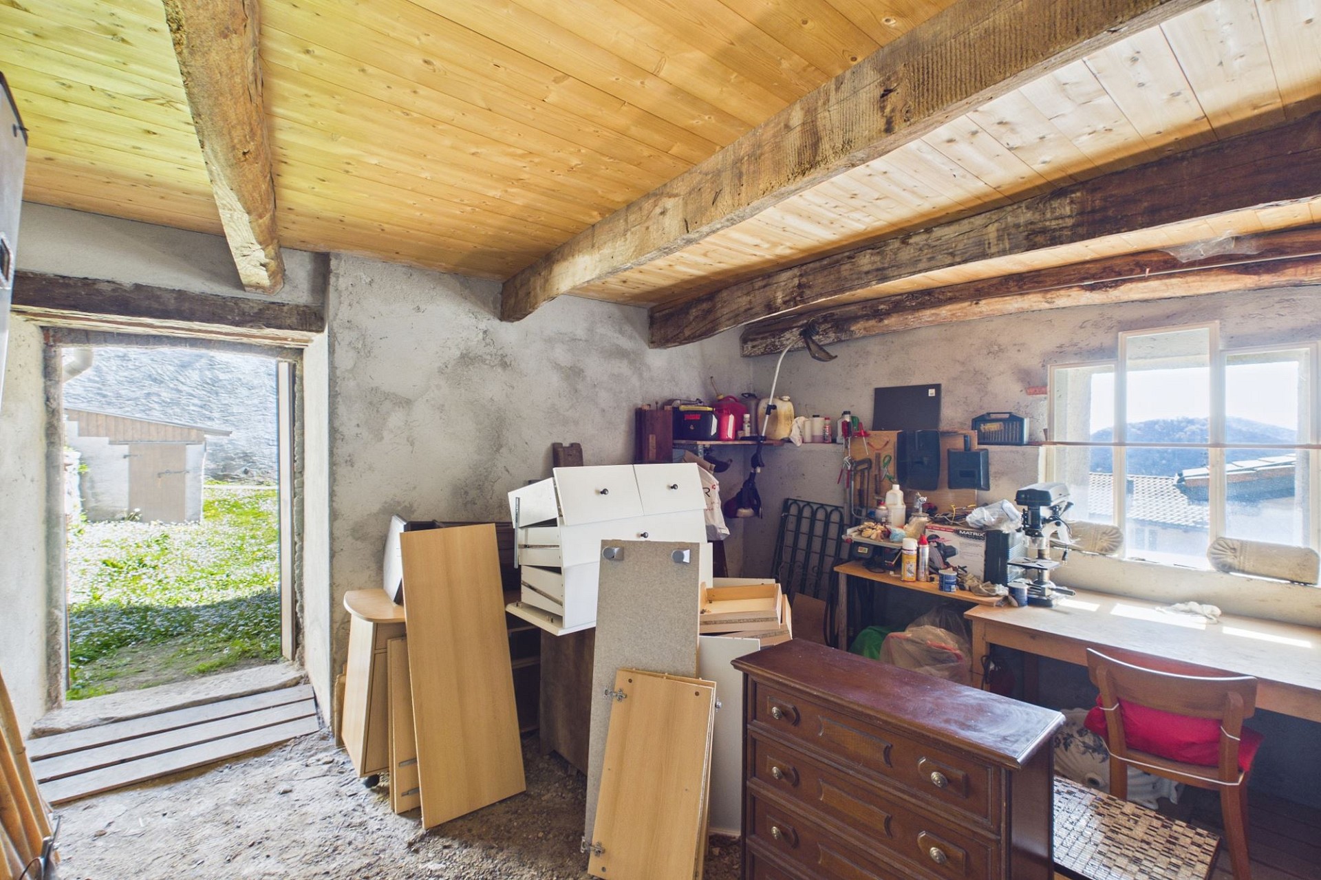Rustikaler Abstell- und Arbeitsraum mit Holzbalkendecke
