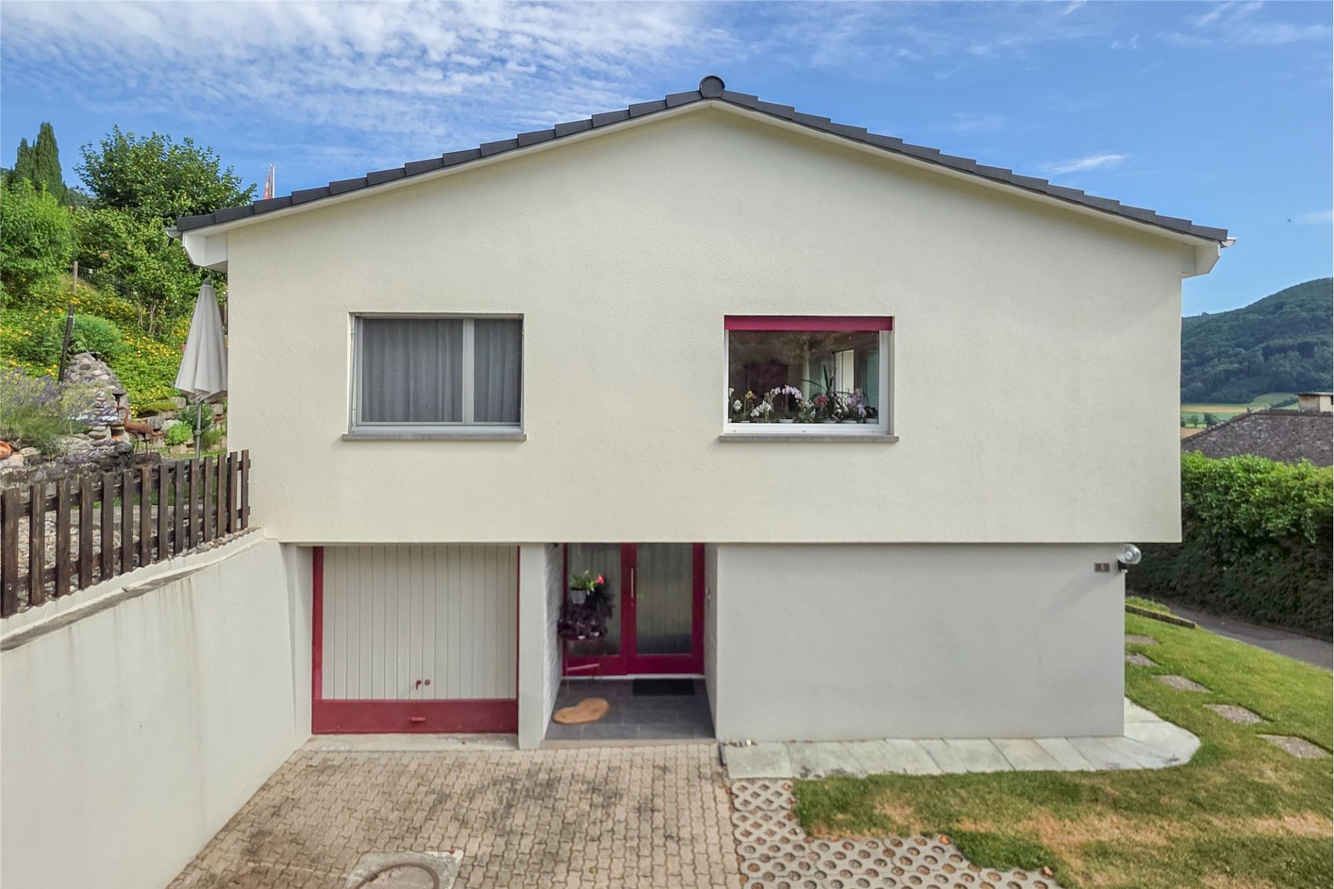 Einfamilienhaus mit Giebeldach und Gartenansicht