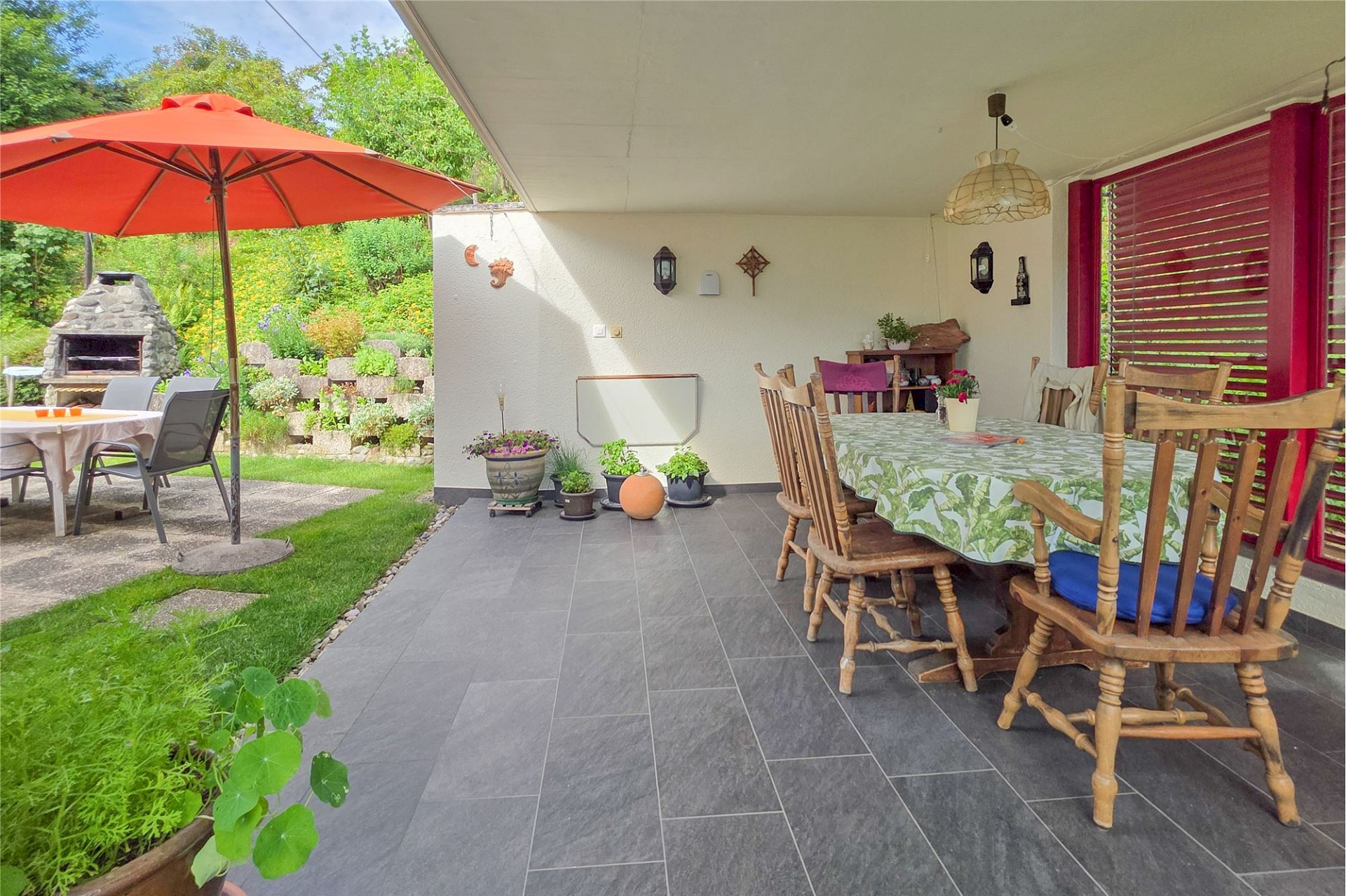 Überdachte Terrasse mit Essbereich und Garten
