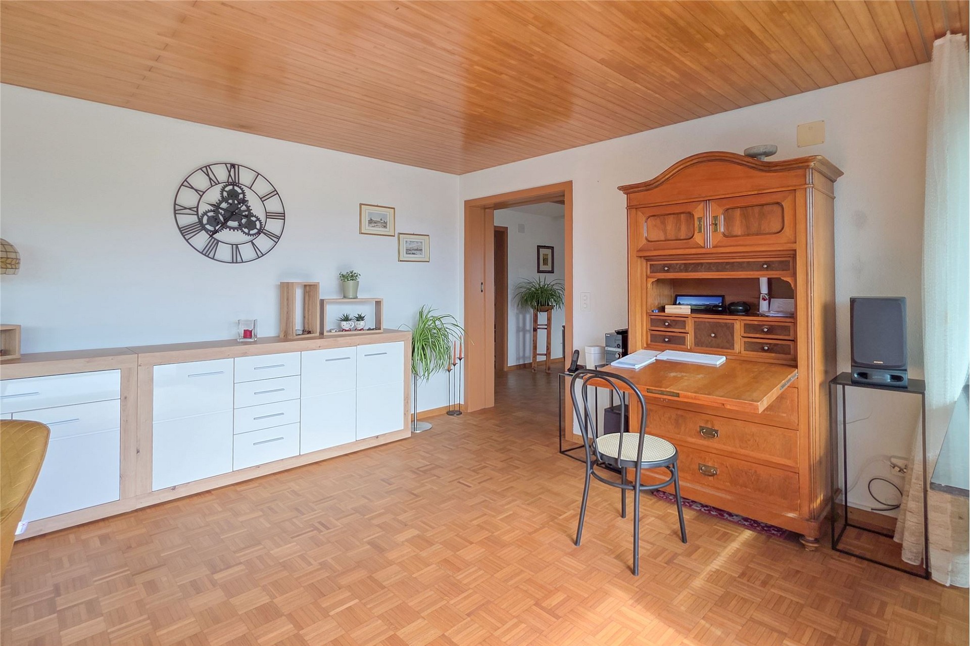 Heller Wohnraum mit Holzdecke und Sideboards