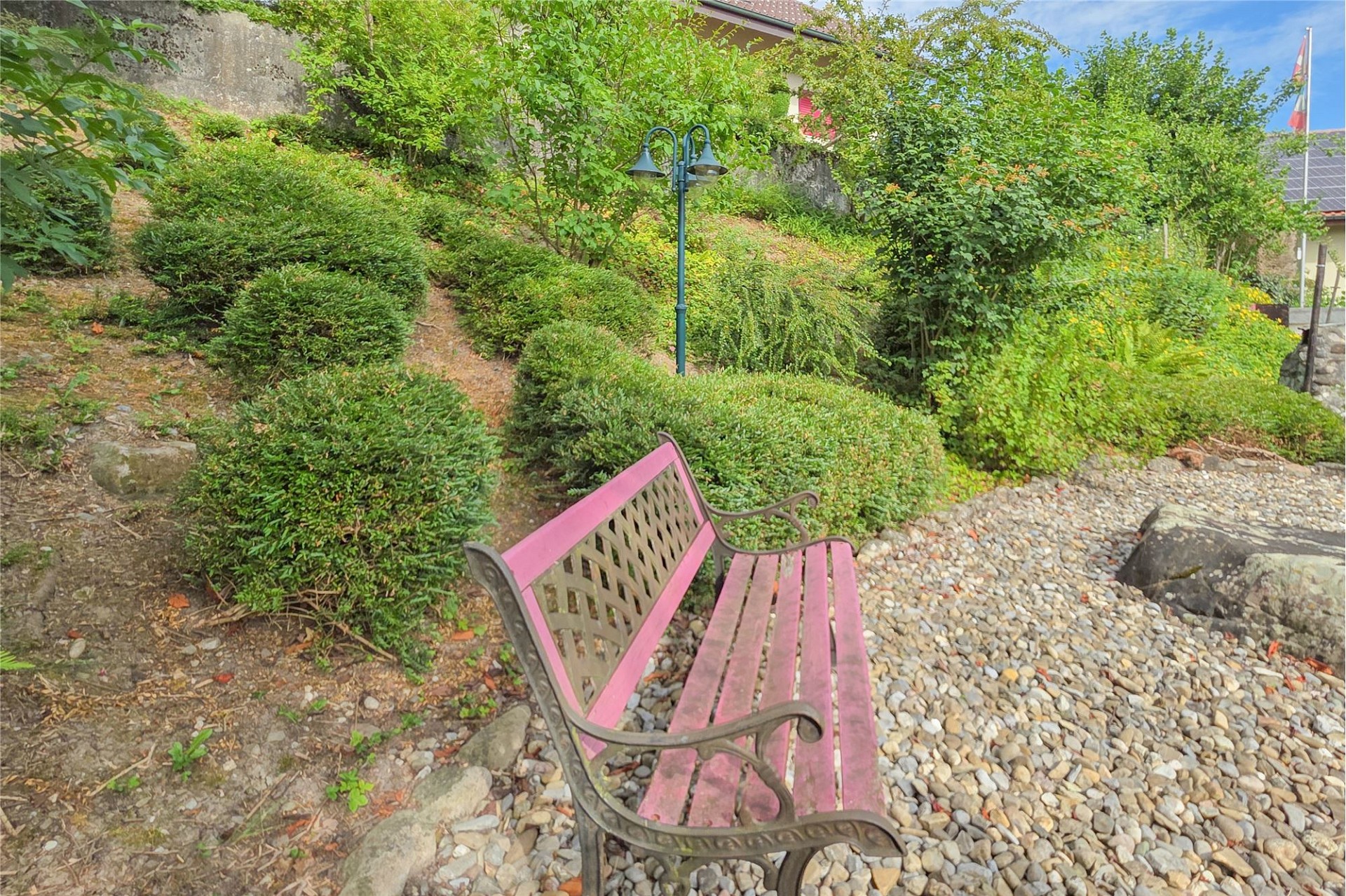 Garten mit Bank und Hangbepflanzung