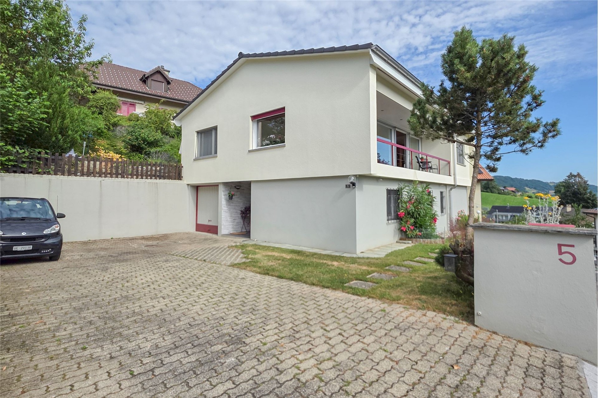 Außenansicht eines modernen Einfamilienhauses mit Hof und Balkon