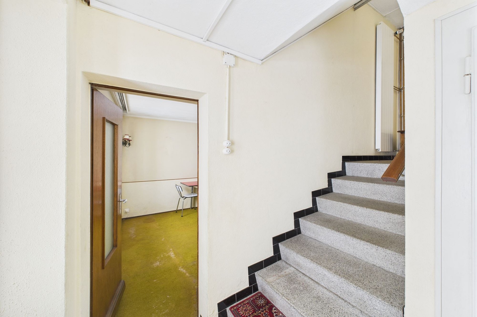Treppenhaus mit Durchgang in einen Nebenraum