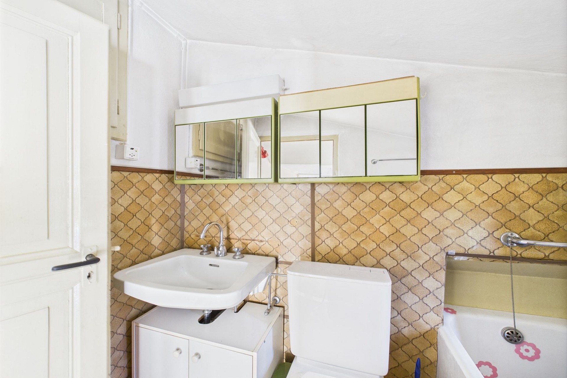 Kleines, älteres Badezimmer mit Waschbecken, Toilette und Badewanne