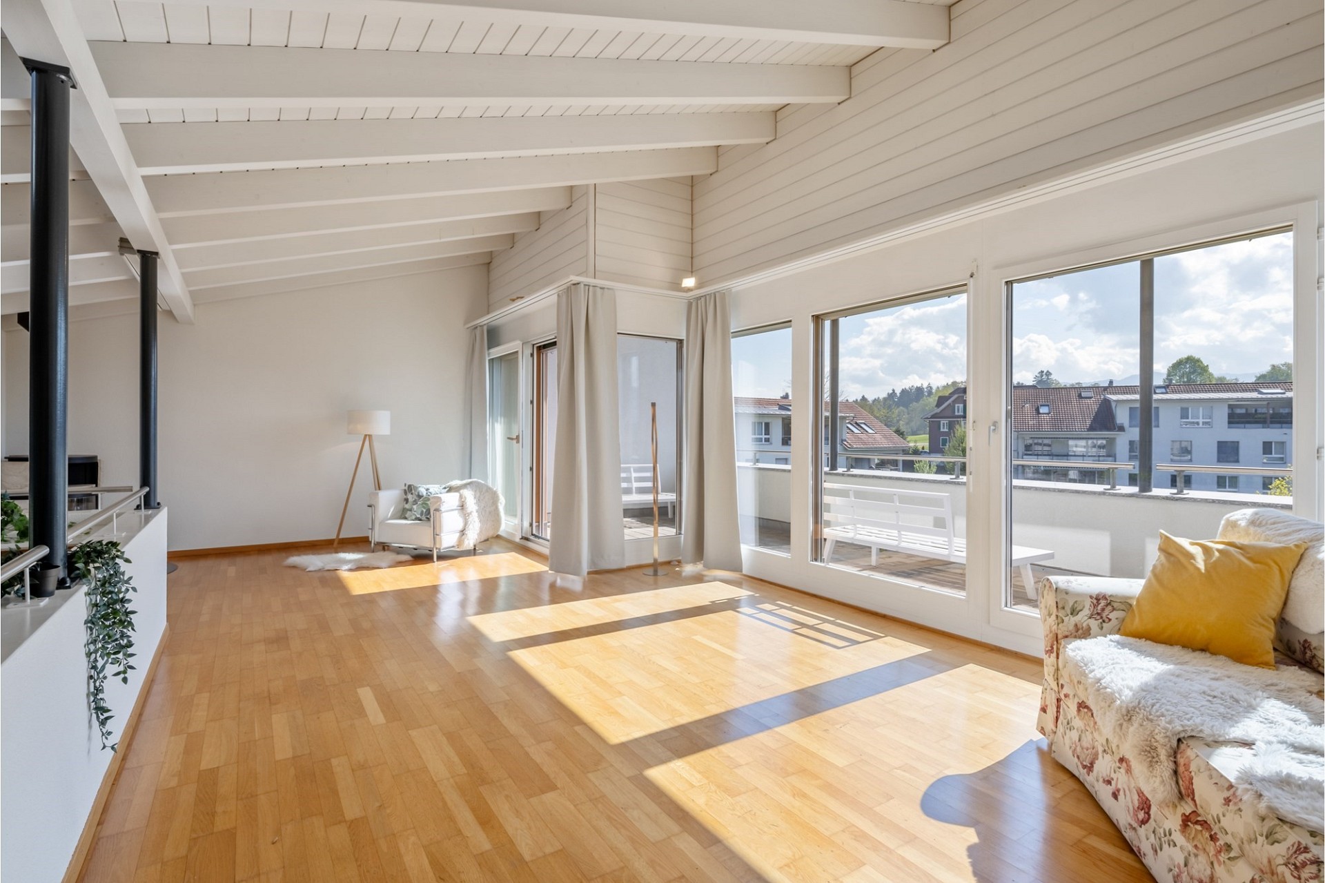 Heller Wohnraum mit Balkon und großer Fensterfront