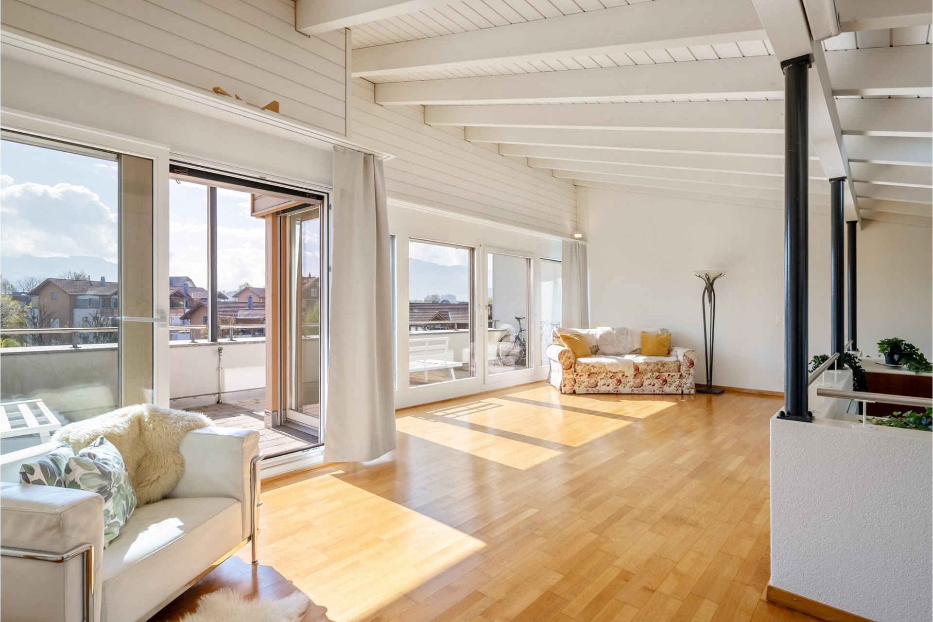 Heller Wohnraum mit Balkon und großer Fensterfront