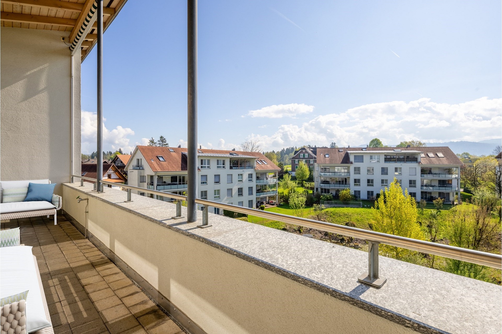 Balkon mit Weitblick über Wohnhäuser und Grünanlage