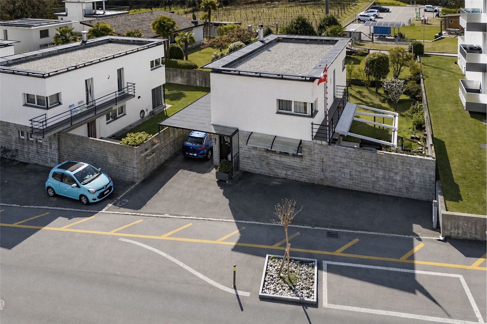 Moderne Wohnanlage mit Flachdachhäusern und Parkplätzen
