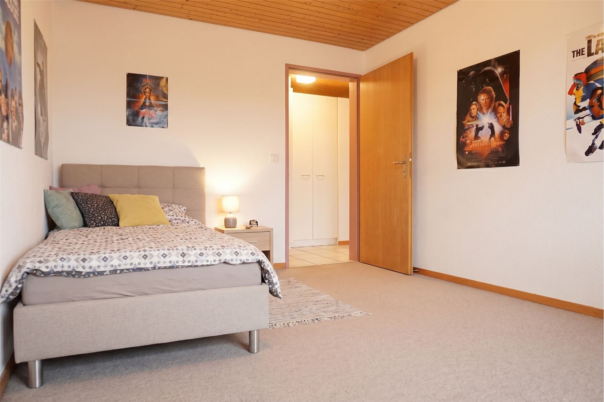 Schlafzimmer mit Bett und Posterwänden