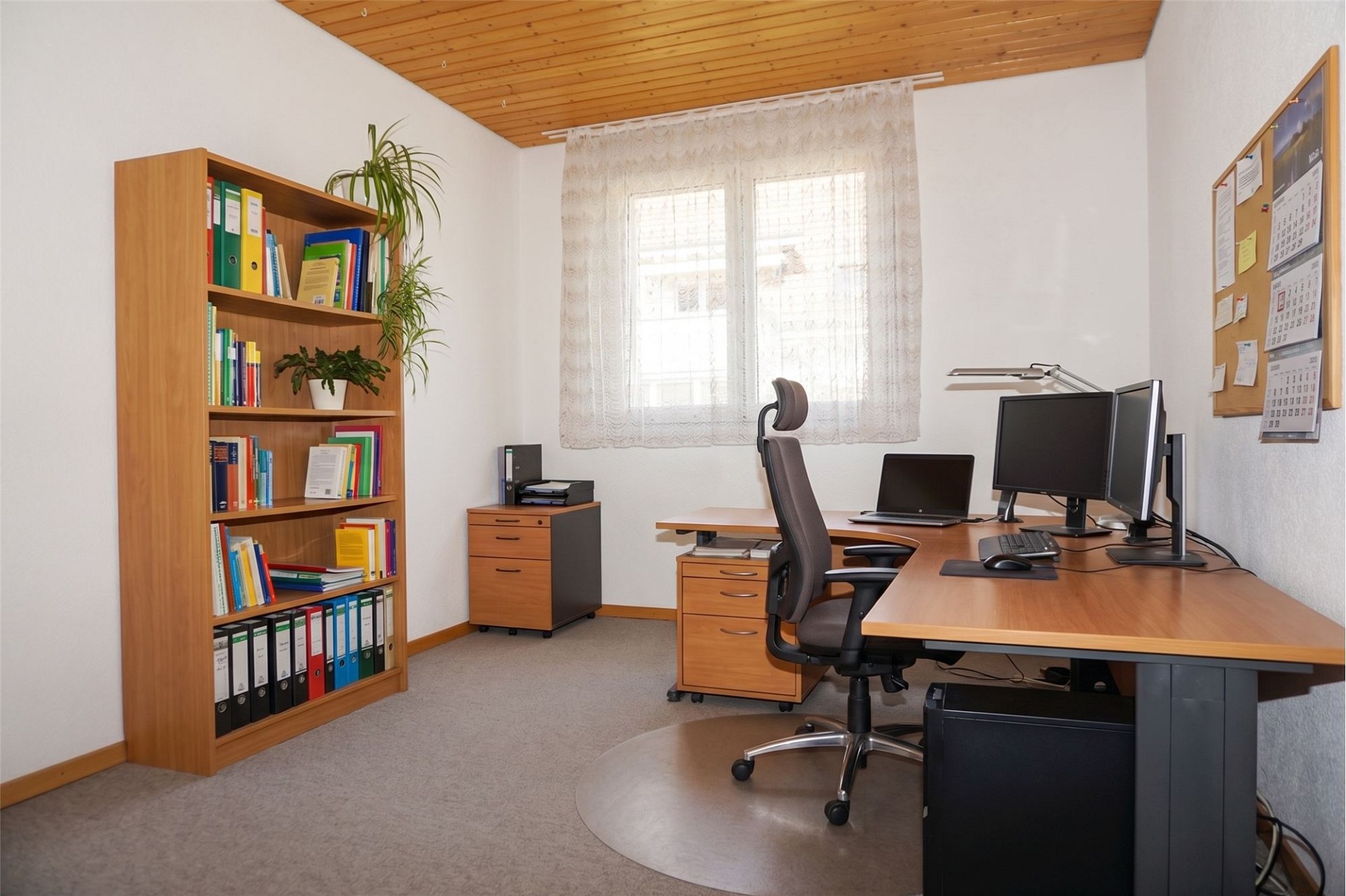 Helles Arbeitszimmer mit Schreibtisch und Regalen